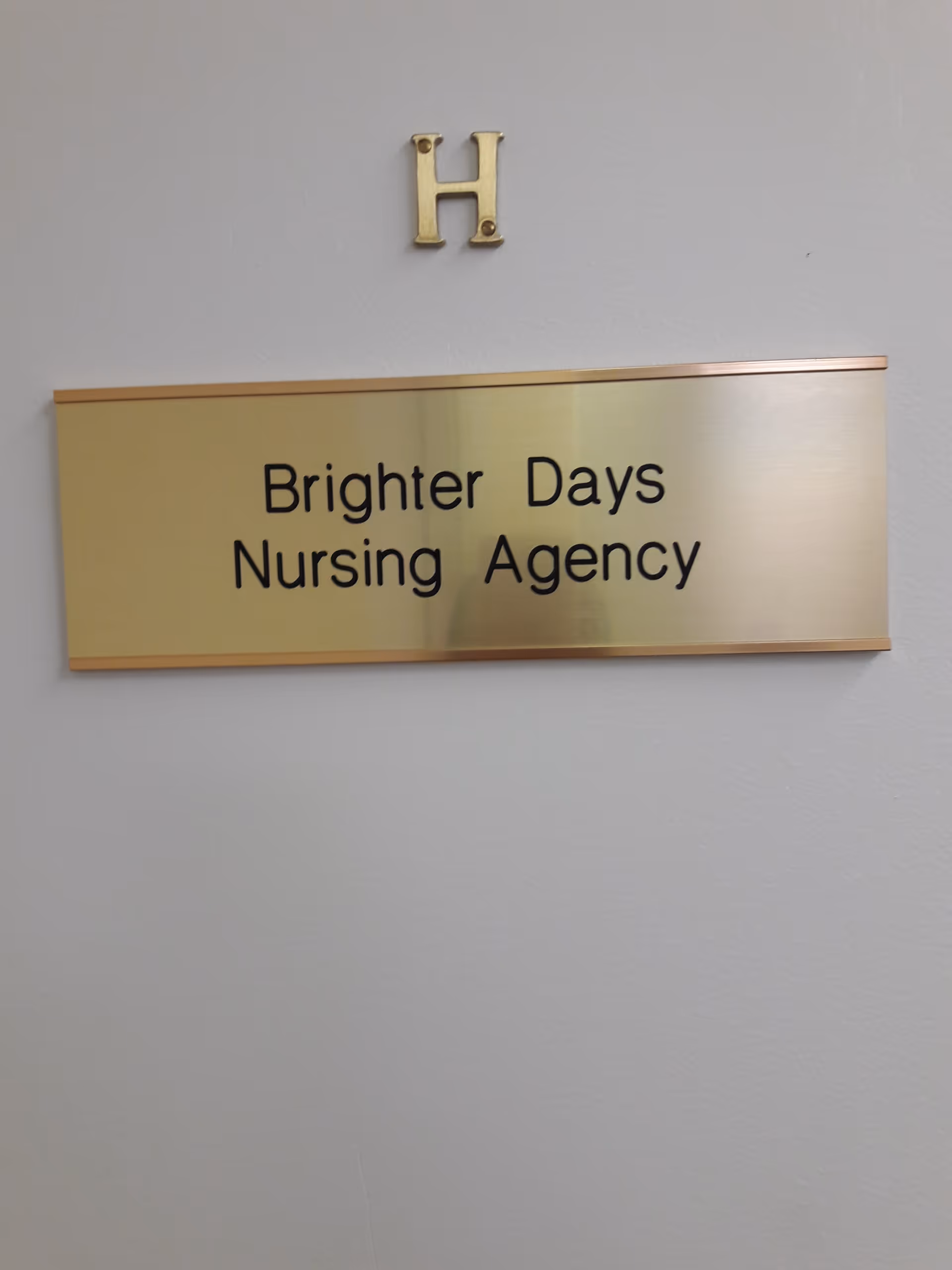 Gold plaque on a pale wall reads Brighter Days Nursing Agency, with an H above.
