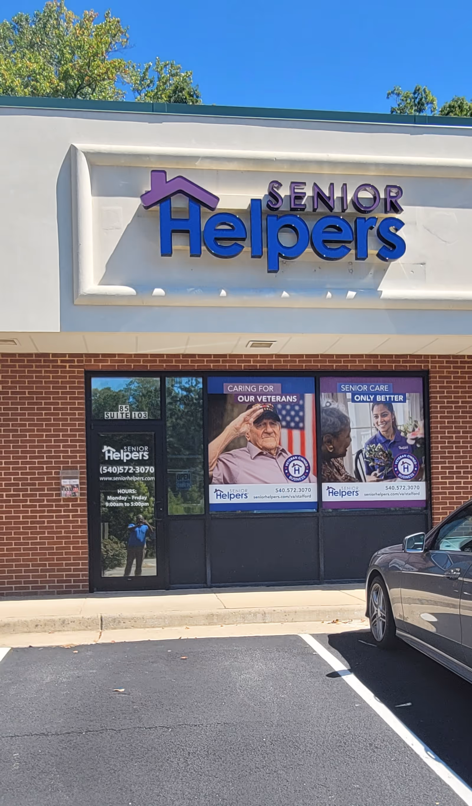Exterior storefront of Senior Helpers senior care facility with blue signage and posters.