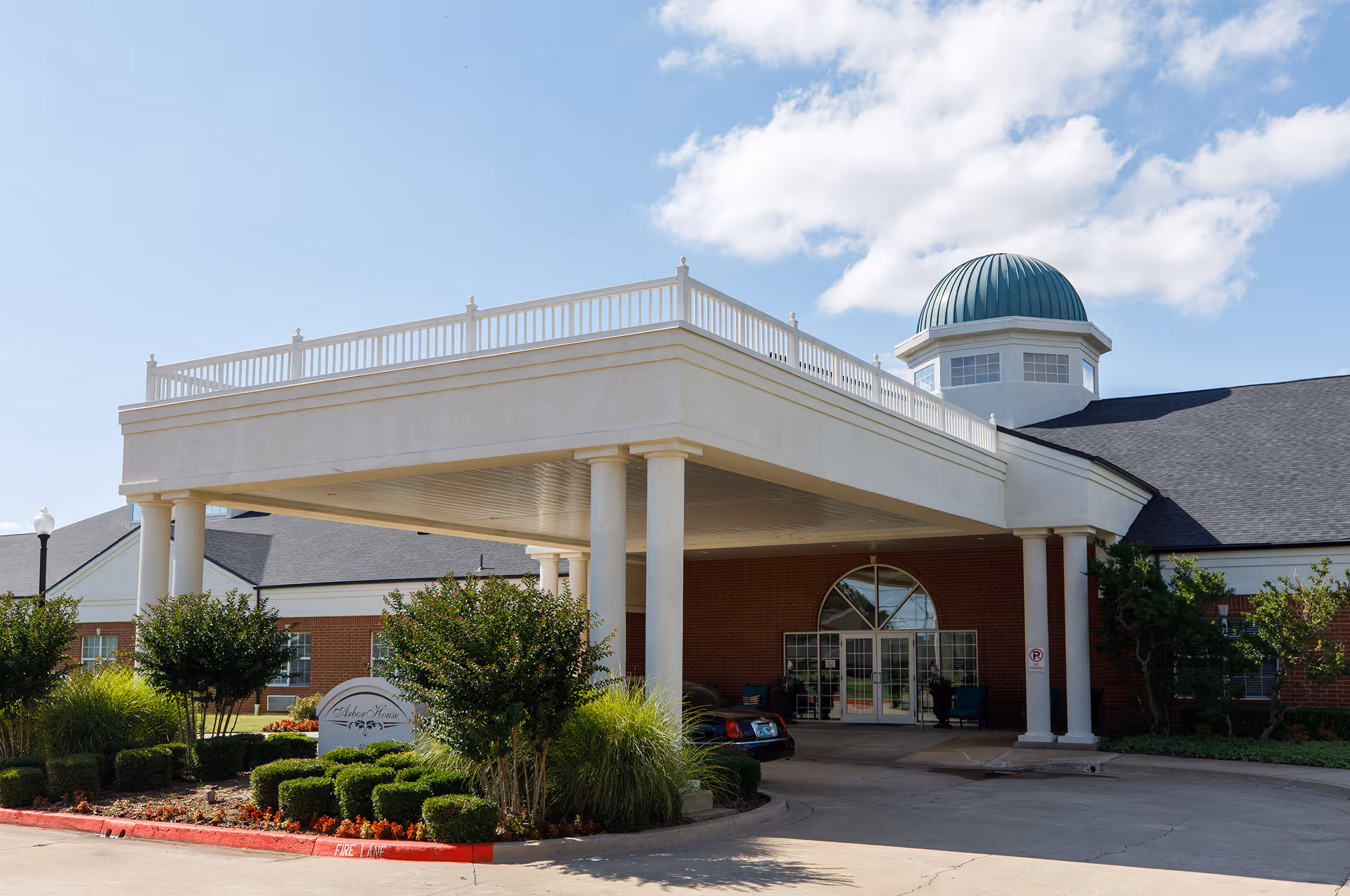 Front view of Arbor House of Norman with a covered entrance and a dome-topped roof.