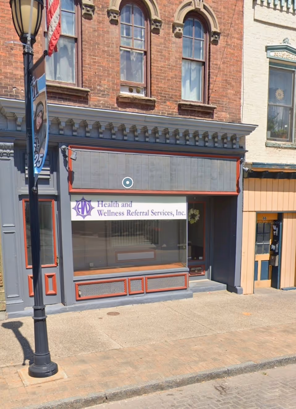 Exterior storefront with Health and Wellness Referral Services sign on a brick building.