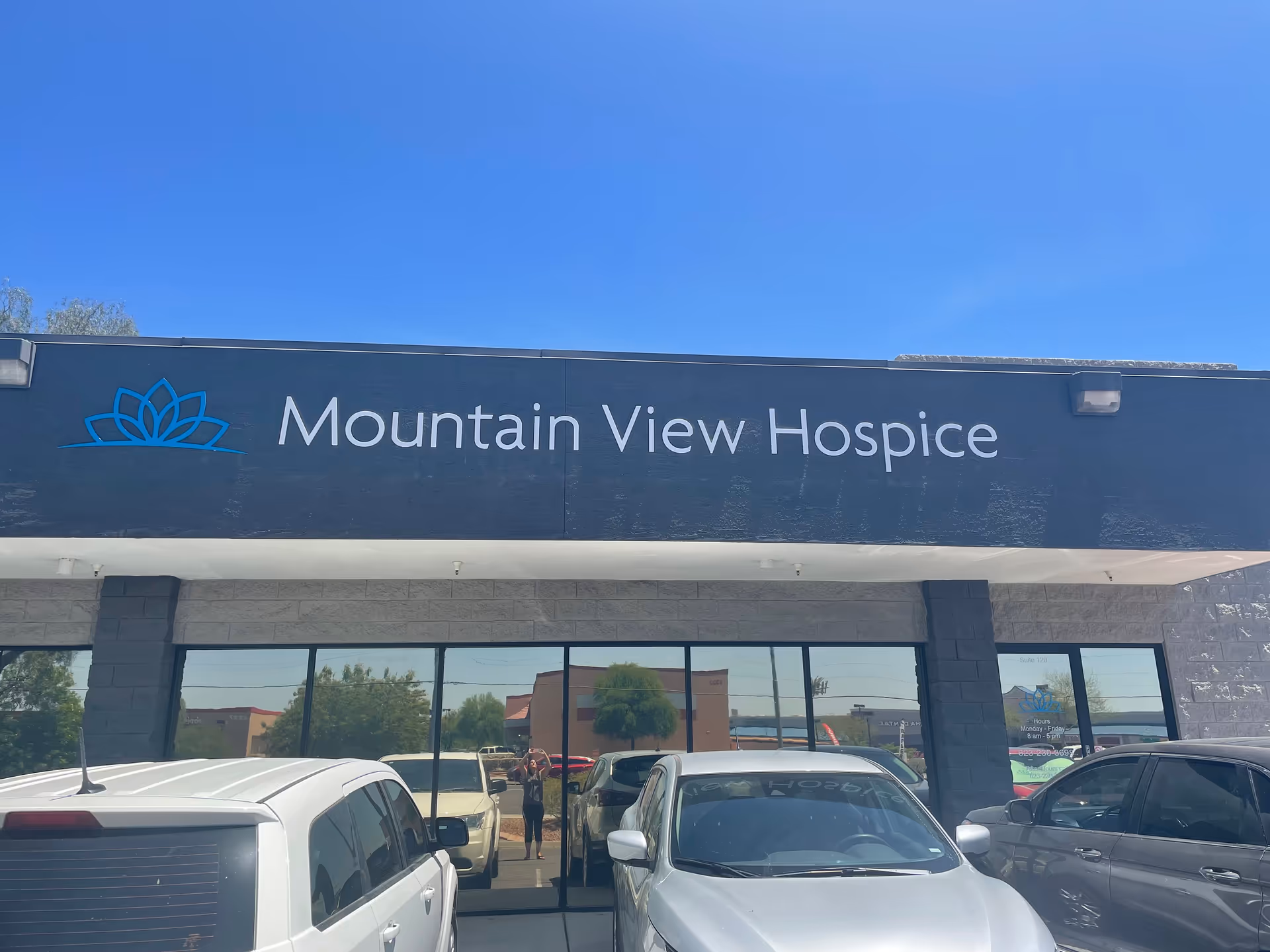 Front exterior of Mountain View Hospice building with signage and parked cars