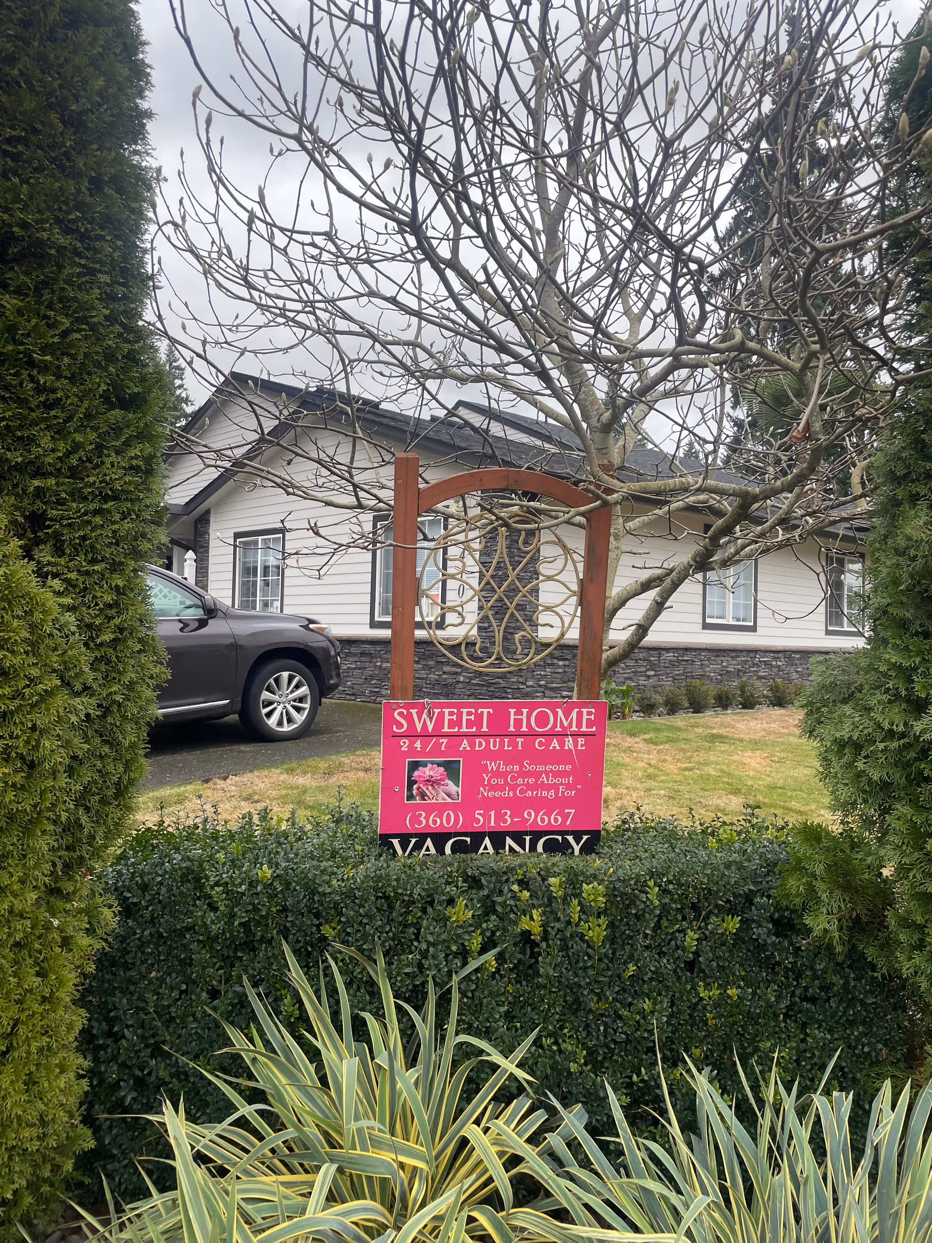 Exterior view of a single-story facility with a pink 'Sweet Home' sign and landscaping.