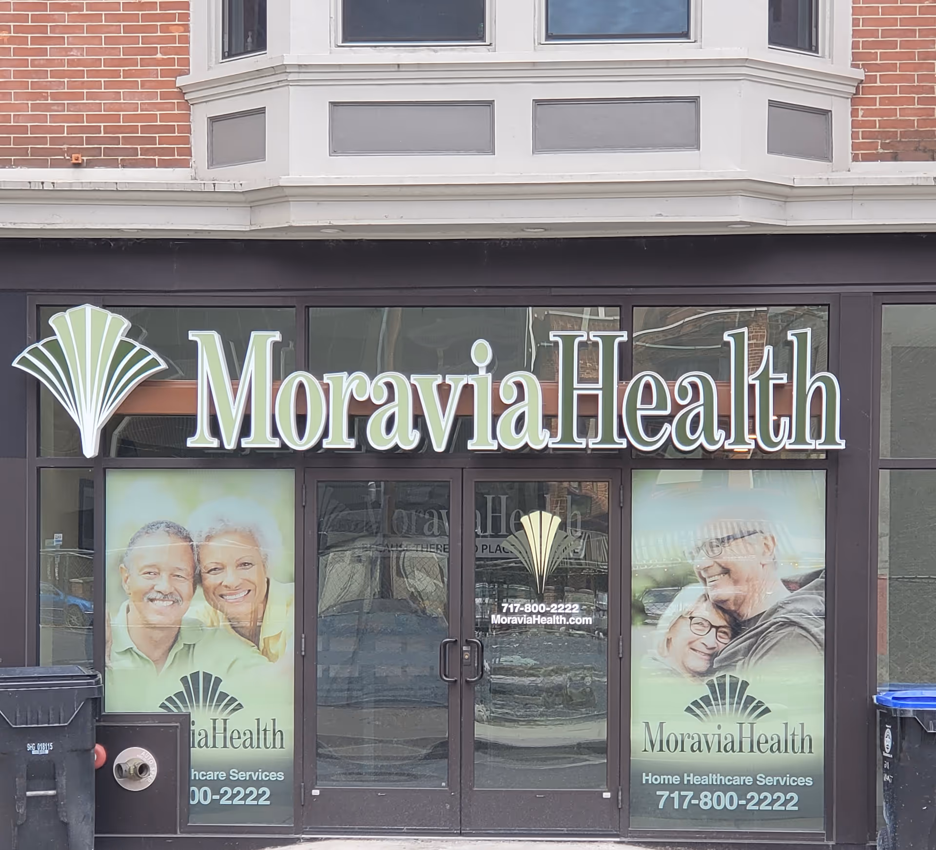 Exterior Moravia Health storefront with signage and promotional posters