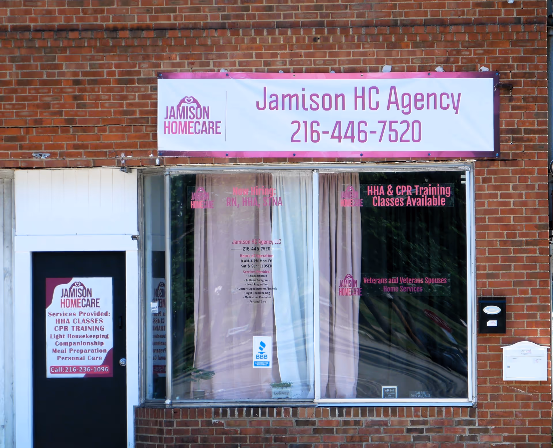 Brick storefront with Jamison HC Agency sign and large front window display