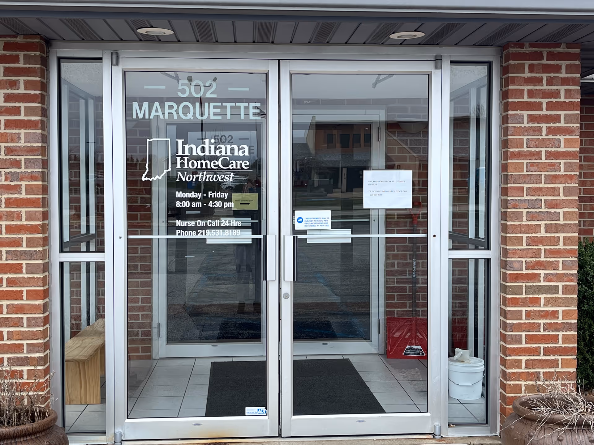 Entrance of Caretenders facility with glass double doors and brick exterior.