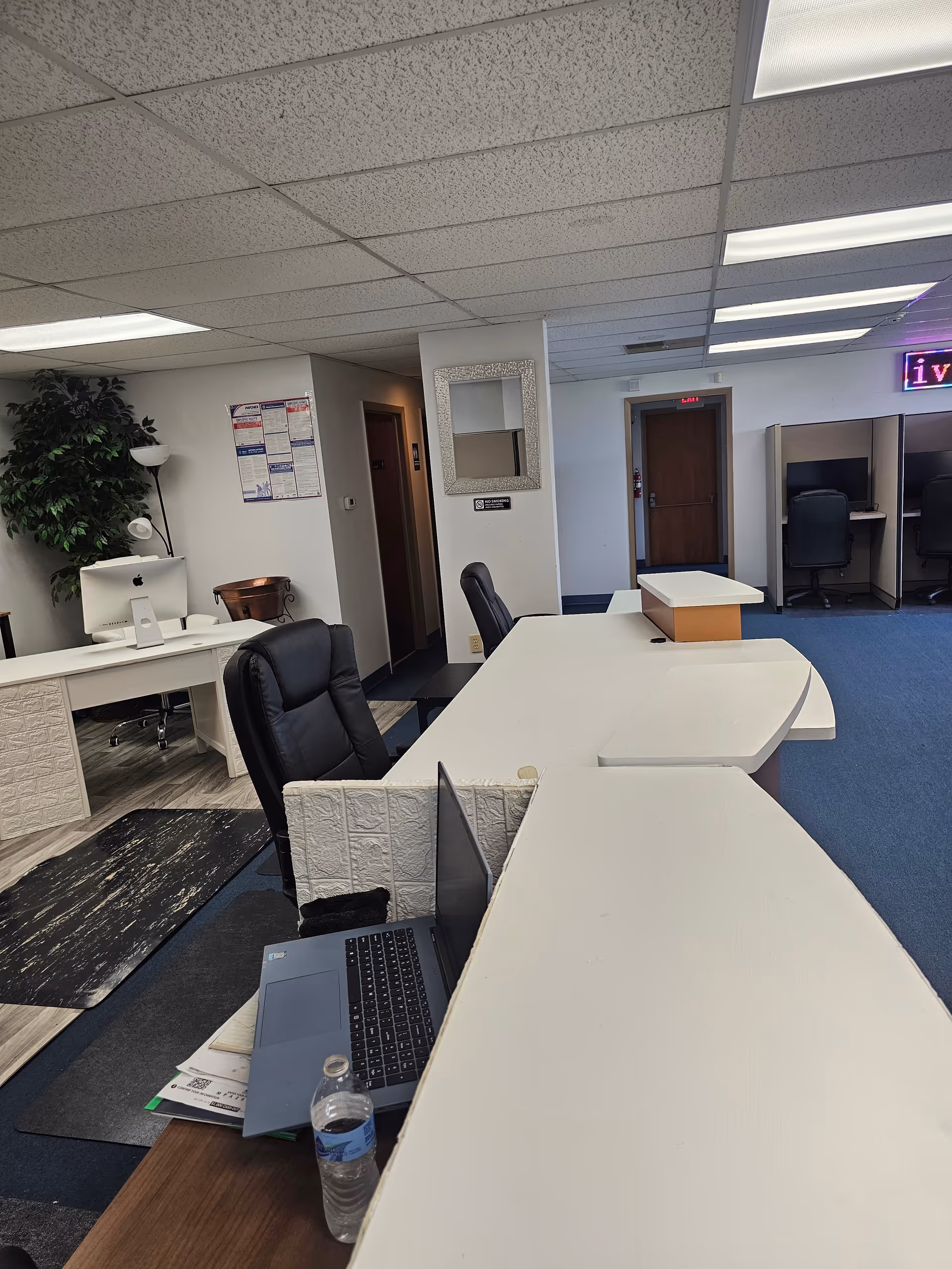 Interior reception area of a senior care facility with a curved white desk and laptop.