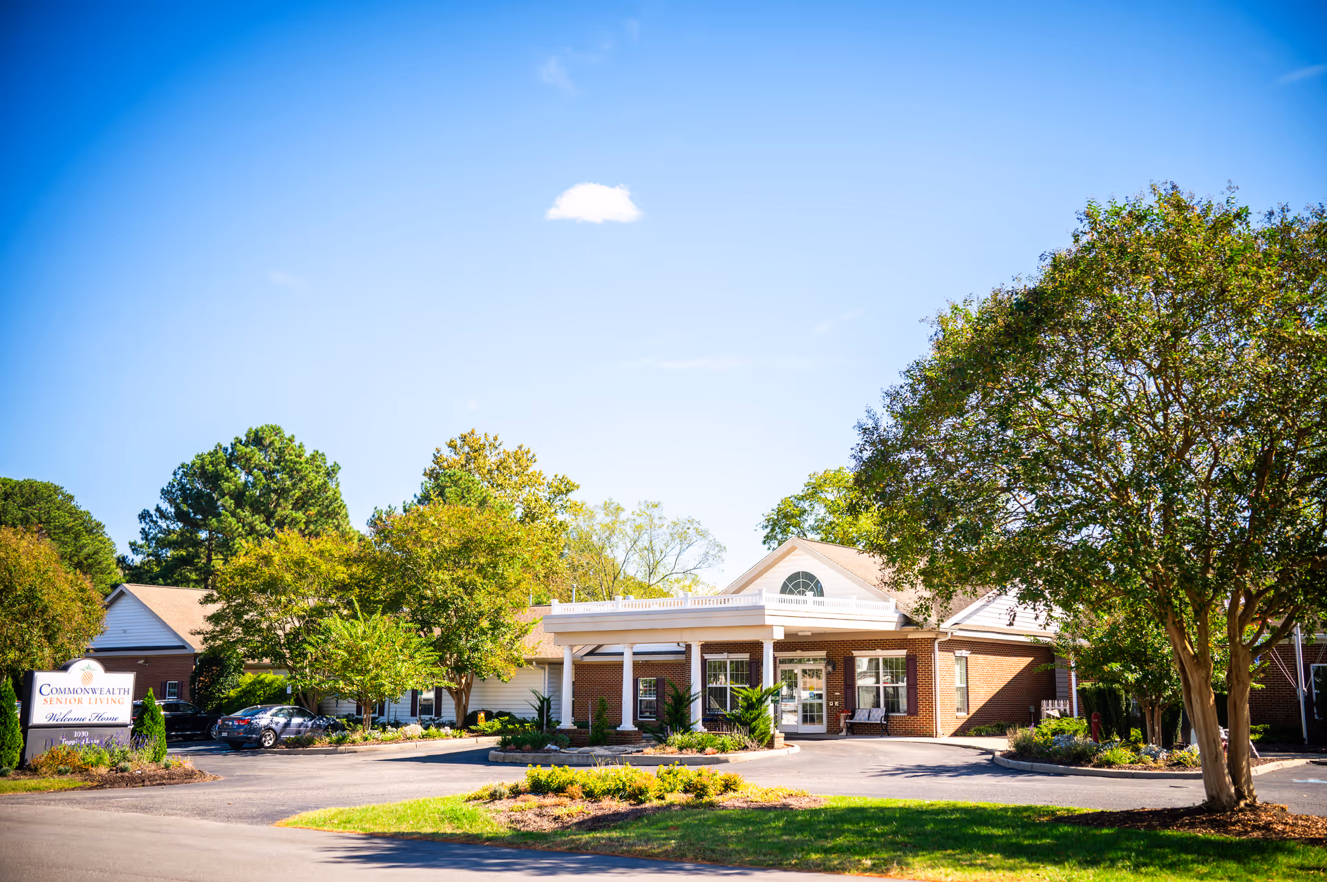 Exterior view of Commonwealth Senior Living at Hampton, showing the entrance and surrounding landscaping.