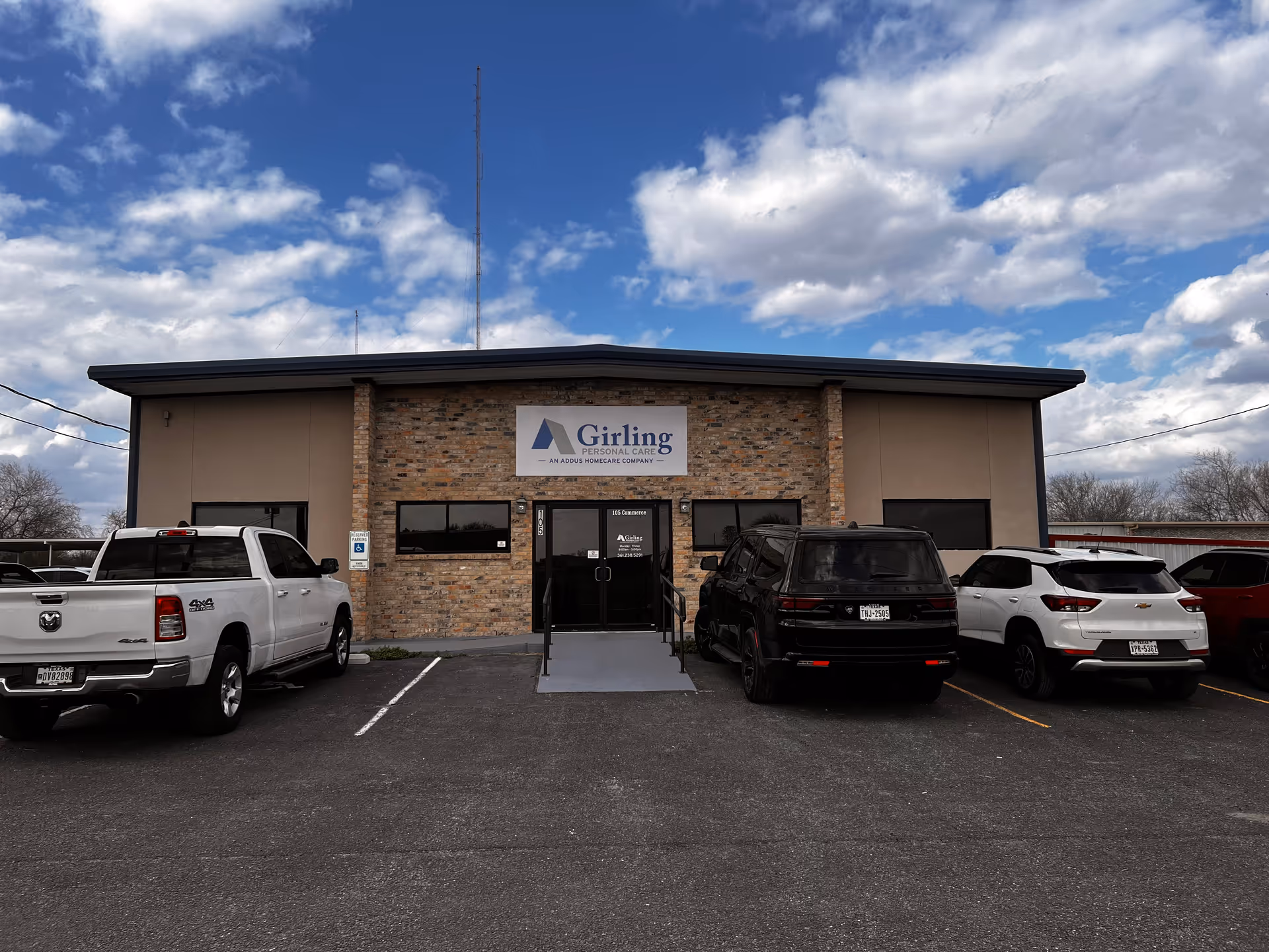 Front view of Girling Personal Care building with brick facade and parked cars.