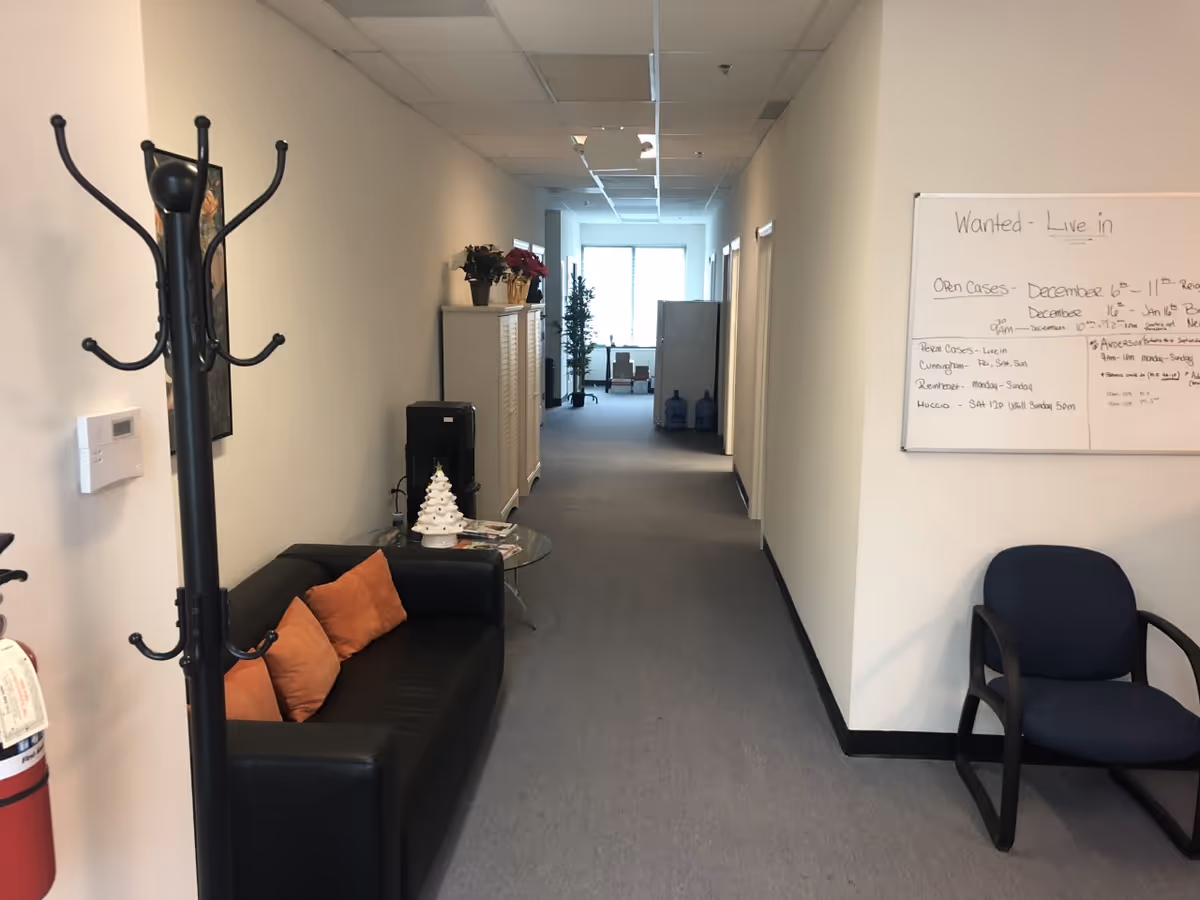 Interior hallway of an IncrediCare senior facility with seating and a whiteboard.
