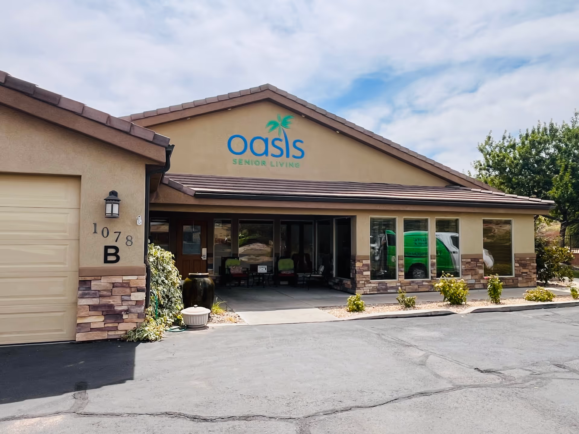 Front view of Oasis Senior Living building with entrance, signage, and green van.