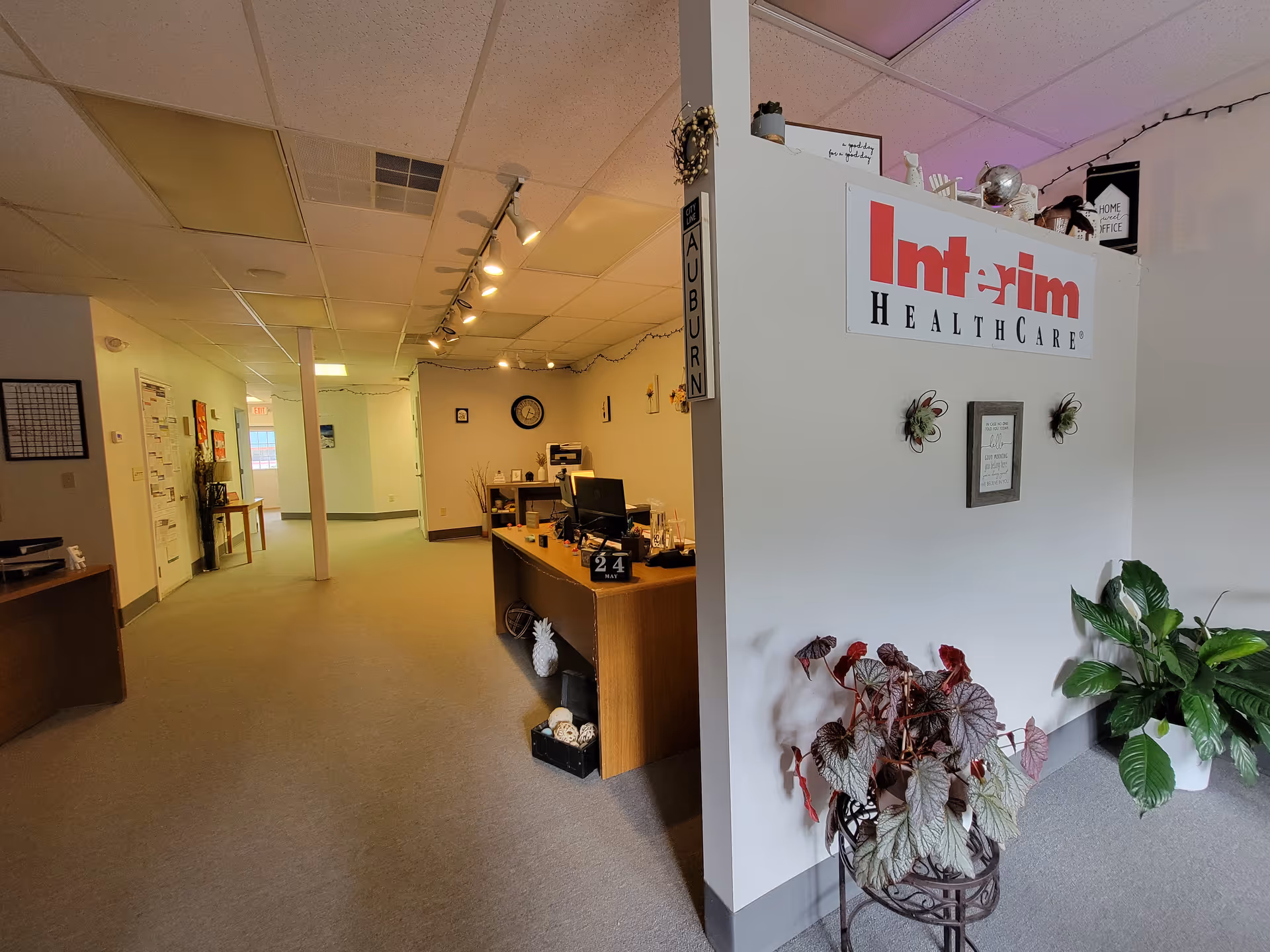 Reception area of Interim HealthCare of Auburn with desks, signage, and plants.