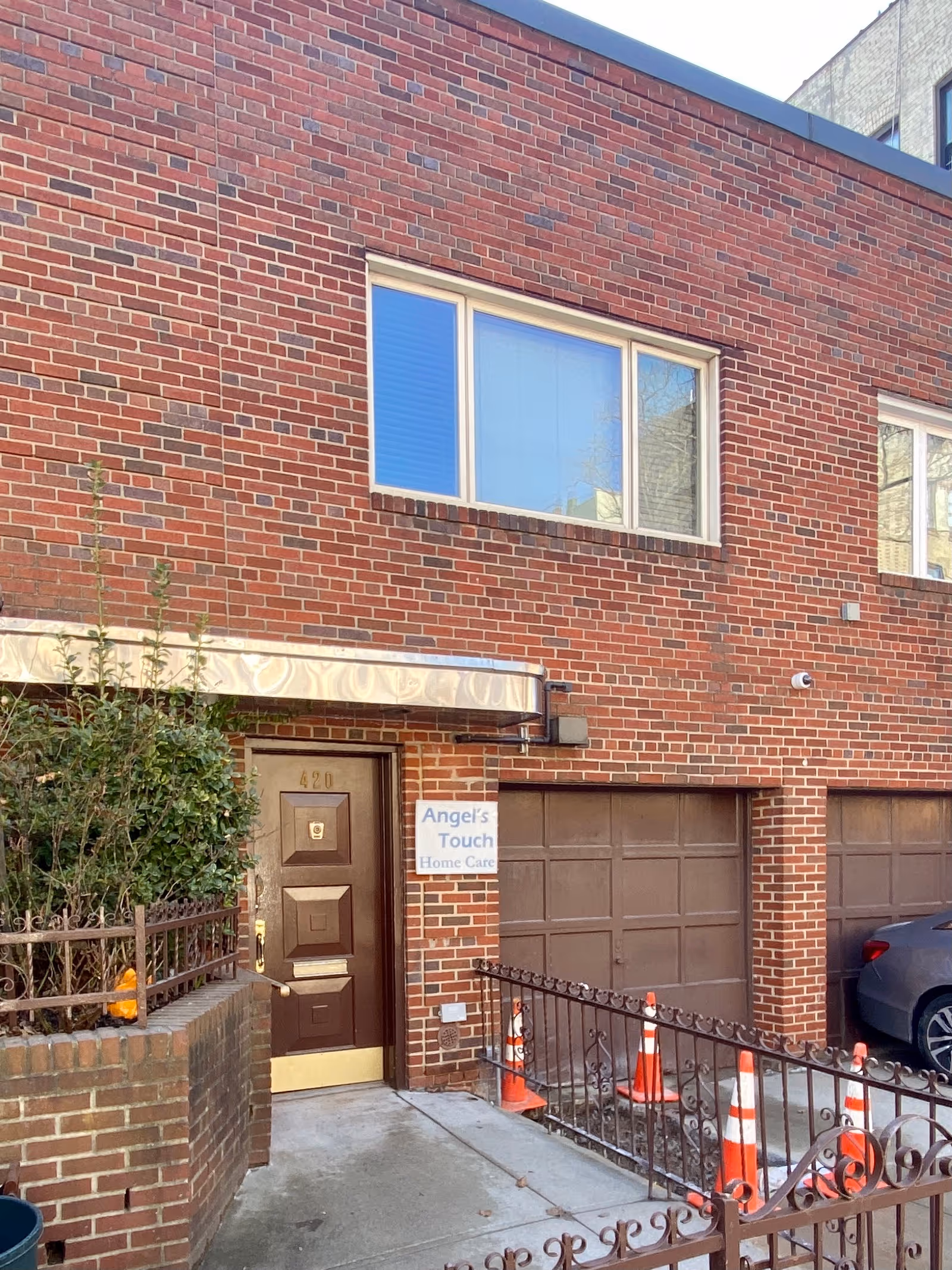 Brick senior care building exterior with front door, sign reading Angel's Touch Home Care, and driveway.