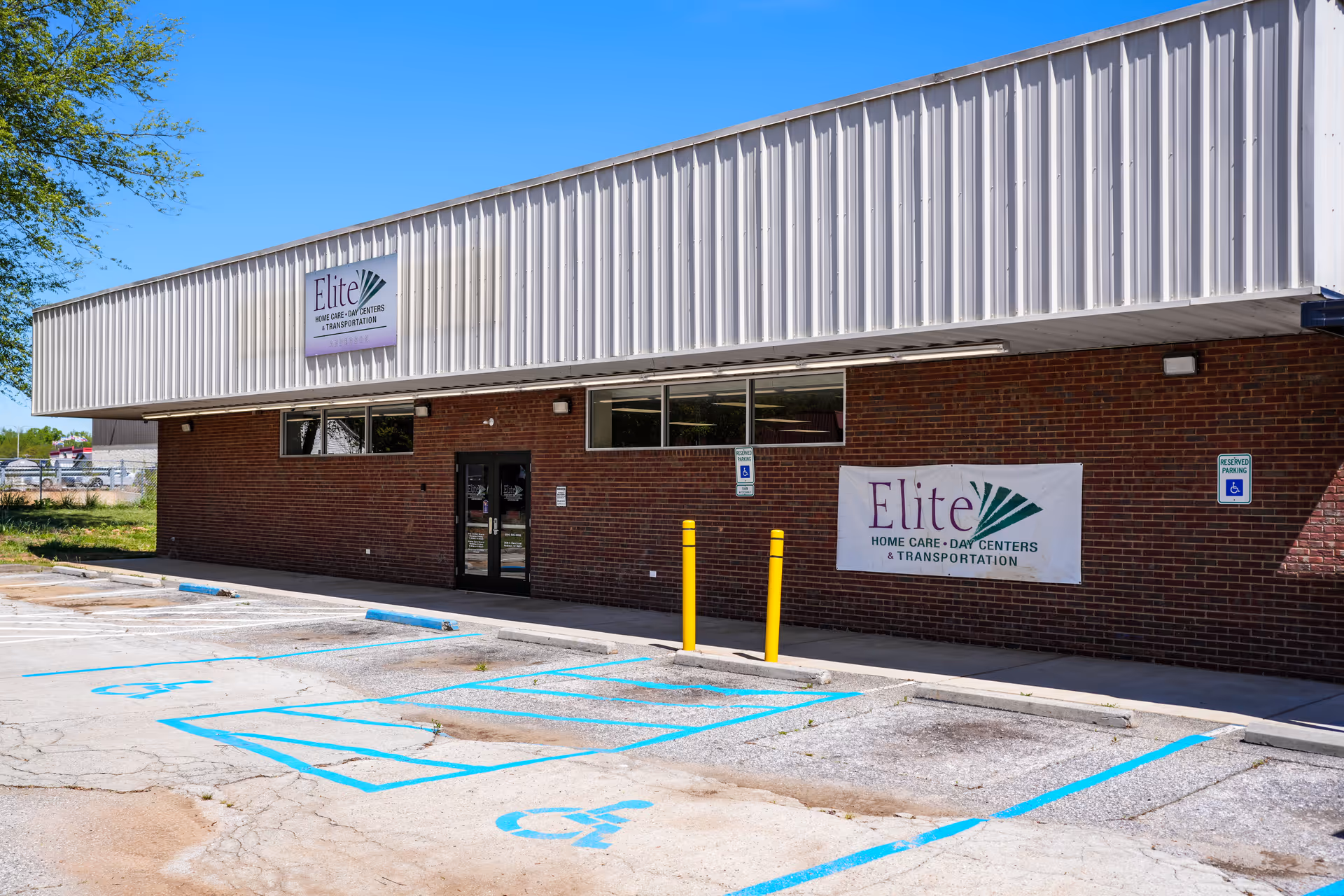 Exterior view of Elite Home Care and Day Centers building with banner, parking lot, accessibility spaces.