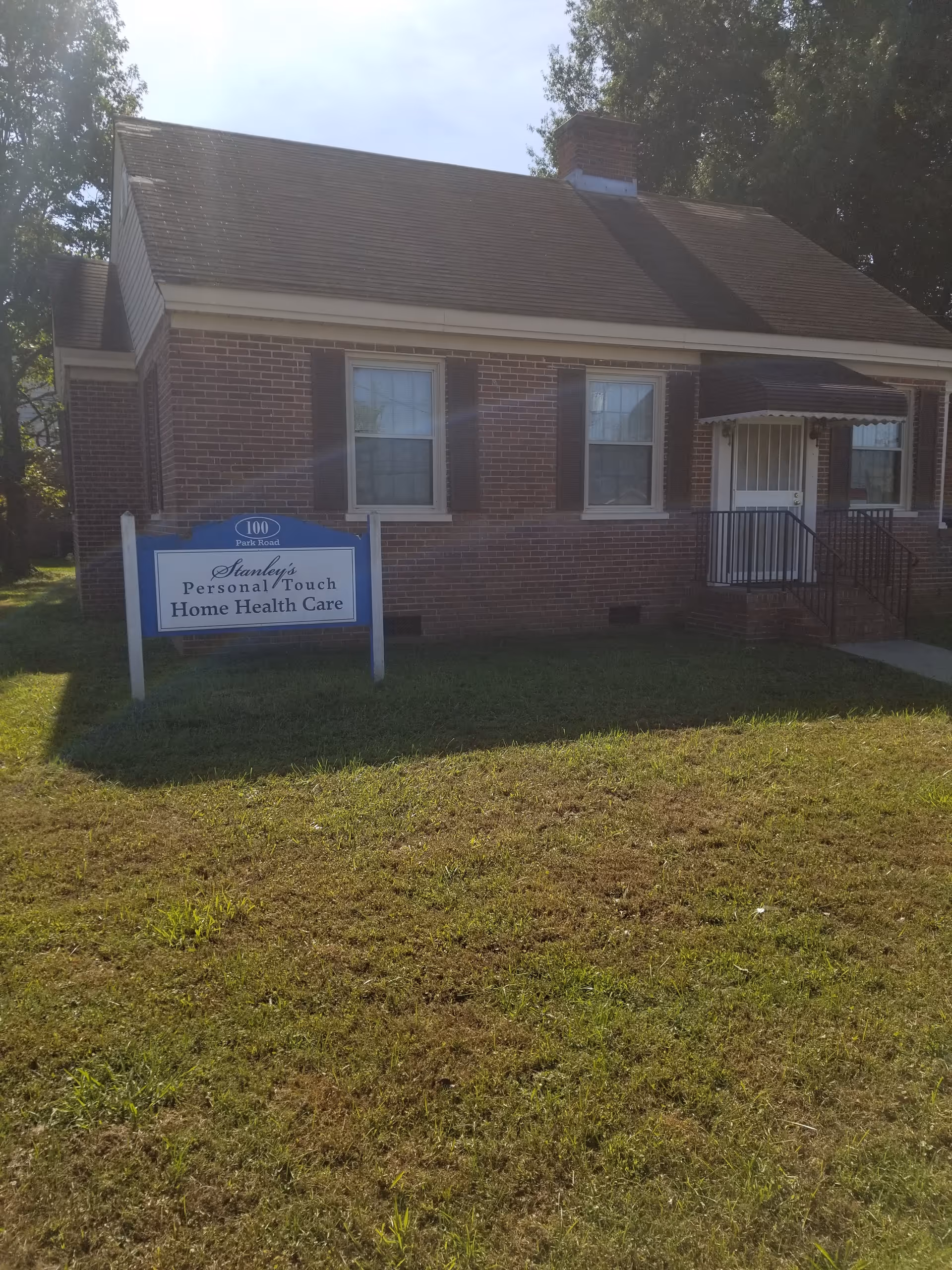 Brick single-story building with a blue sign reading Stanley's Personal Touch Home Health Care.