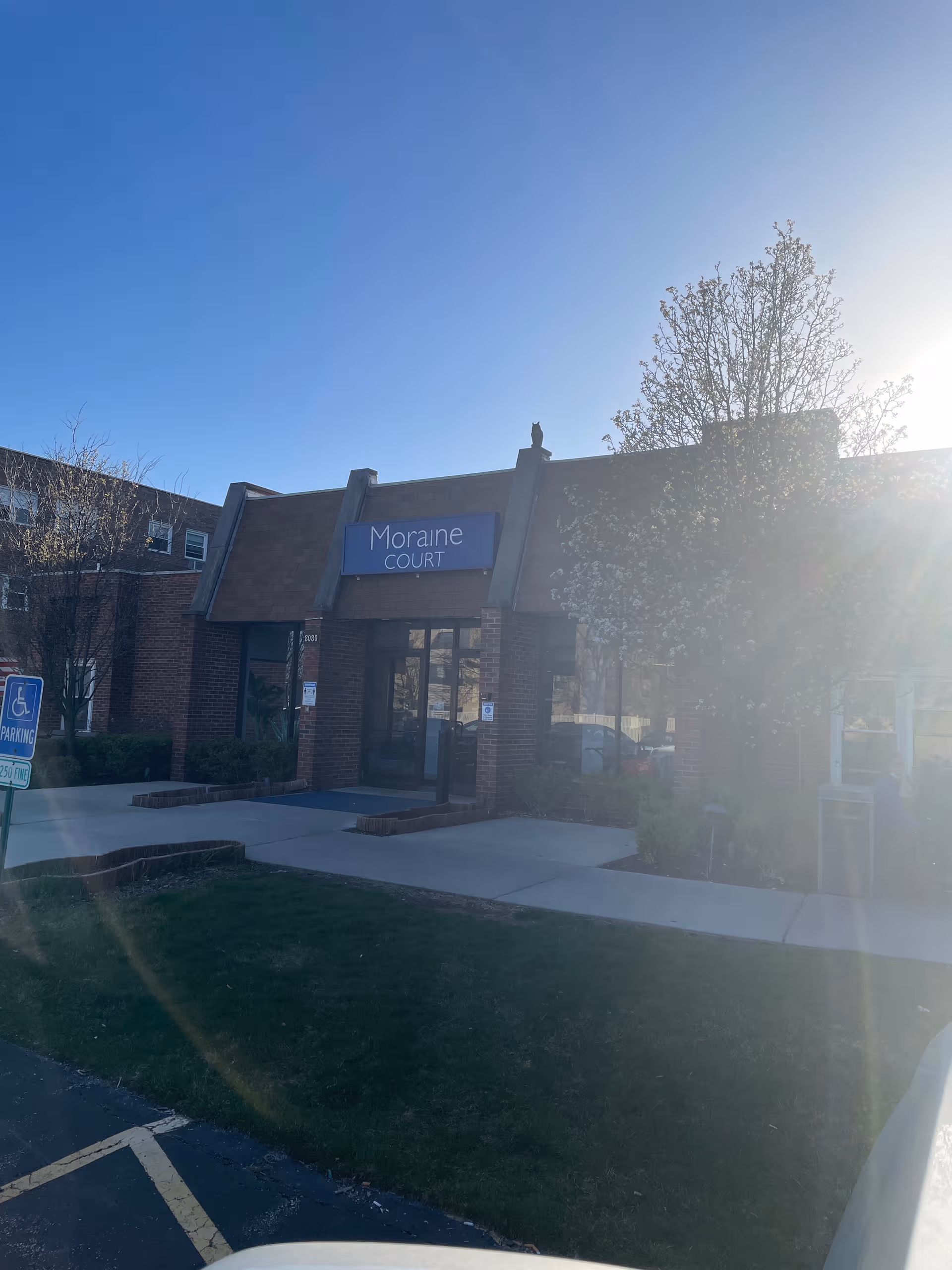 Front view of Moraine Court Supportive Living entrance with sign and glass doors