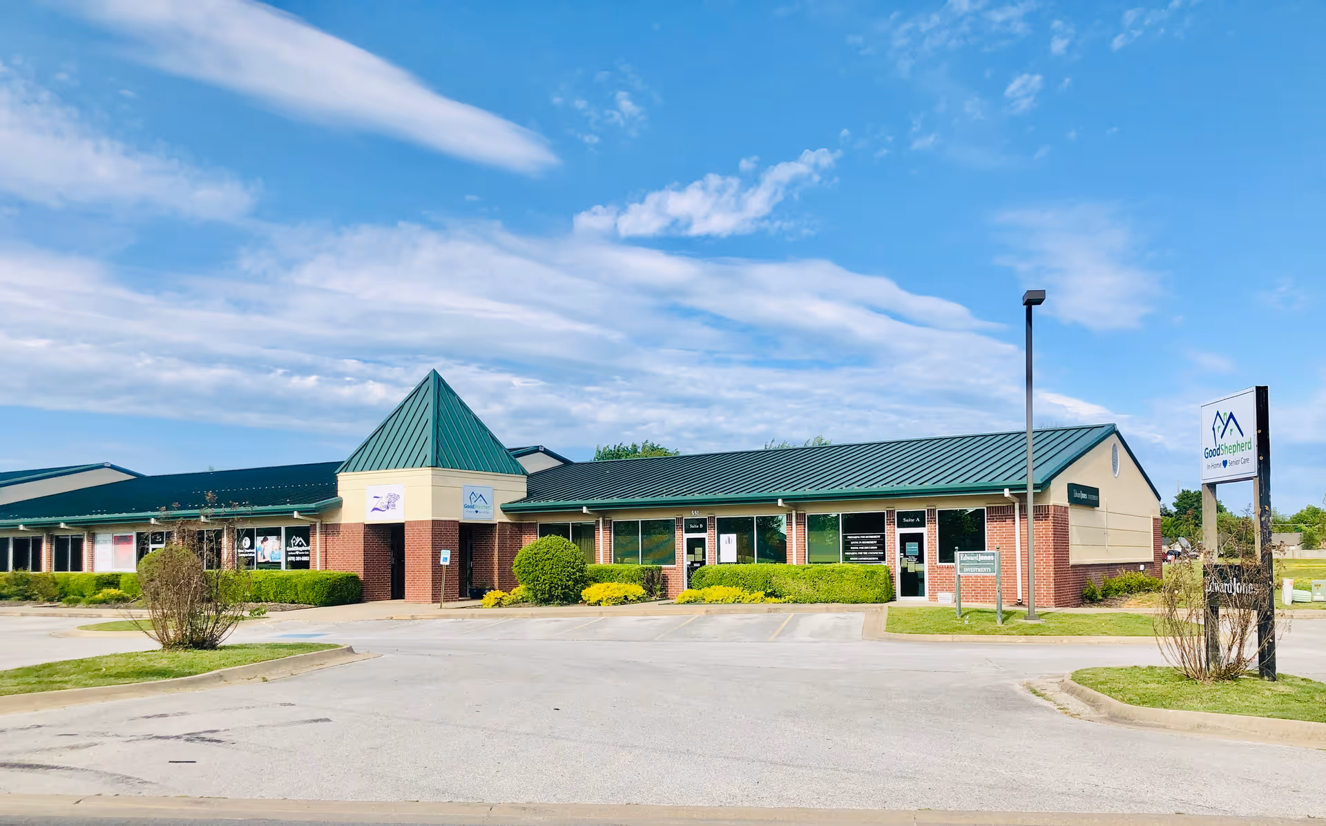 Single-story brick building with green roof and a Good Shepherd In Home Senior Care sign