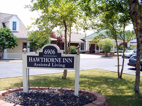 Exterior view of a senior living facility with a front sign reading Hawthorne Inn Assisted Living.