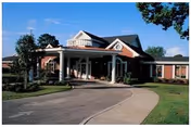 Front exterior of Magnolia Manor with curved driveway and columned entrance.