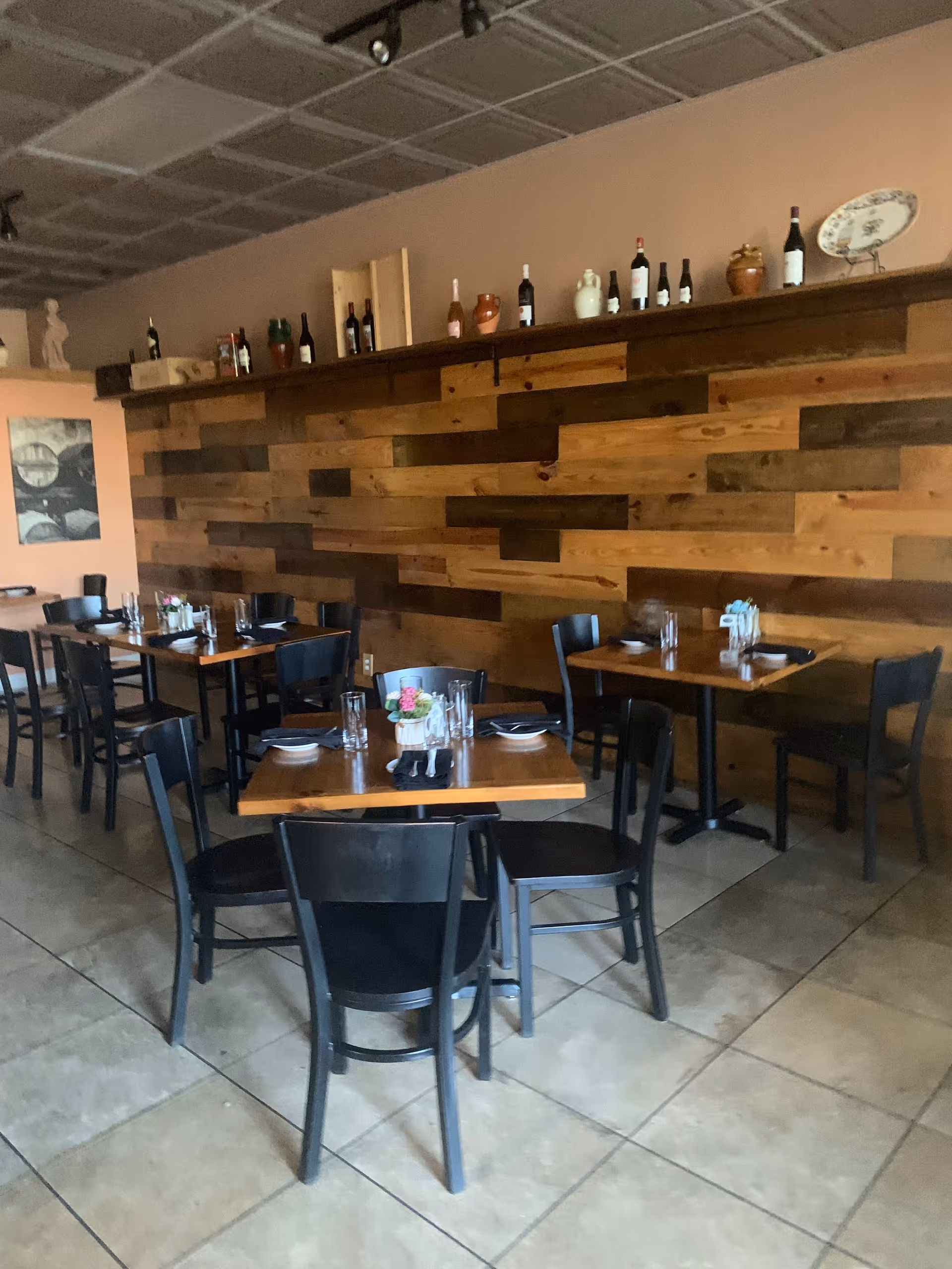 Cafe-style dining area with a wooden wall and tables set for meals.