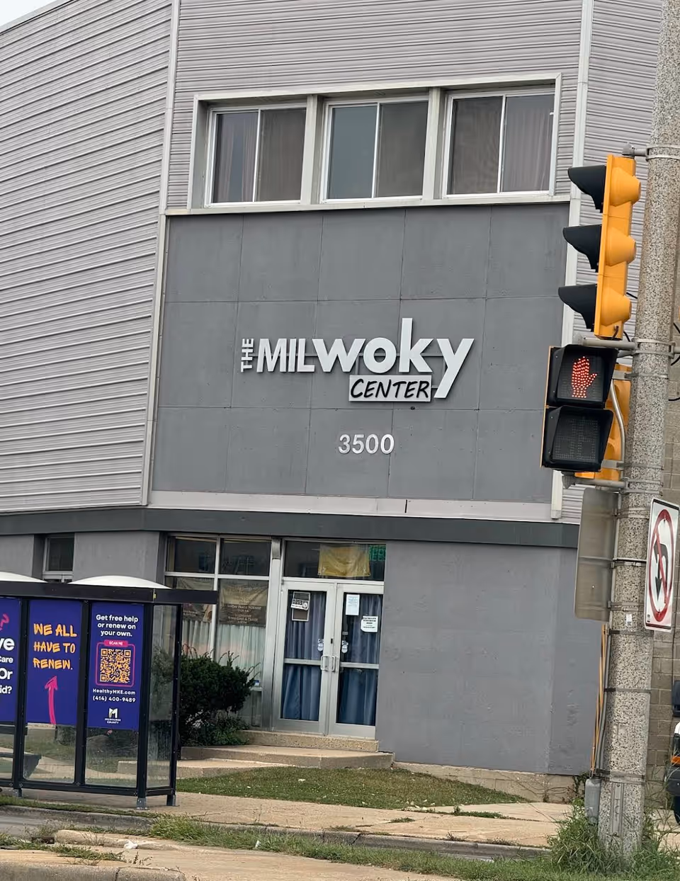 Exterior view of The Milwoky Center storefront with a street traffic light.