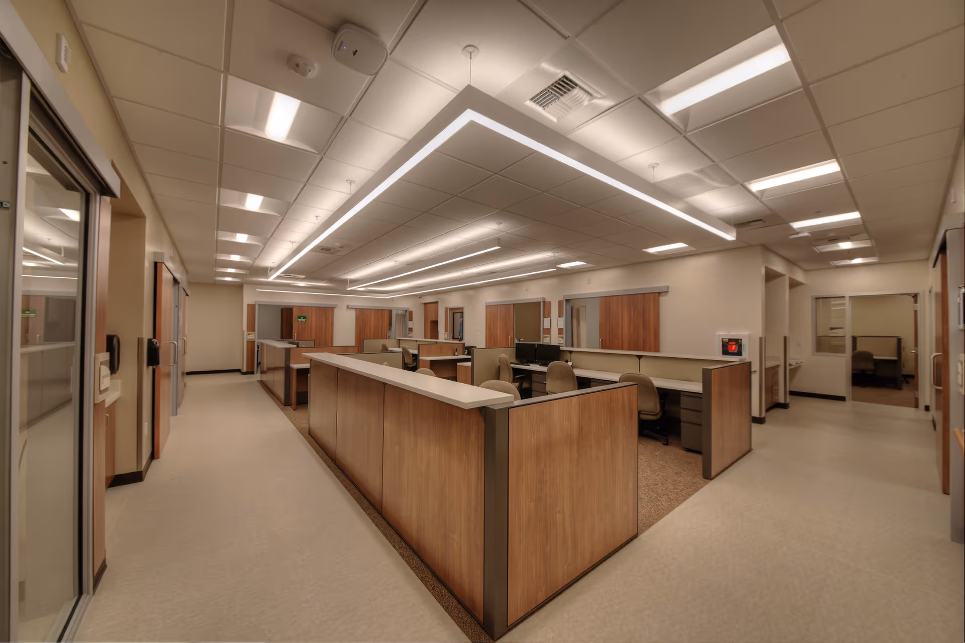 Interior of a spacious reception area with workstations and wooden counters.