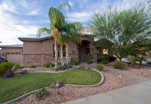 Front exterior of a single-story assisted living facility with desert landscaping