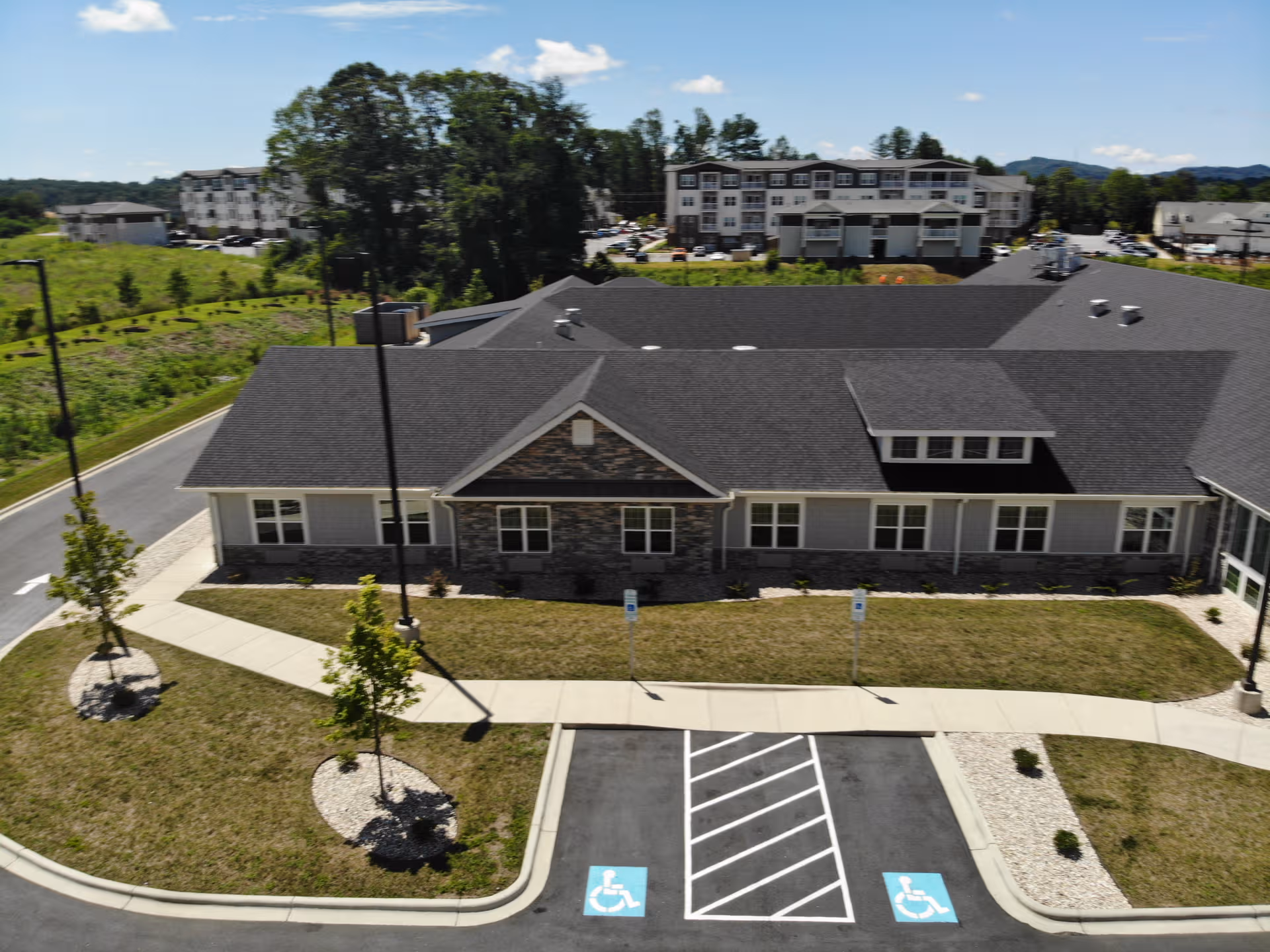 Aerial view of a senior living building with parking and landscaped grounds.