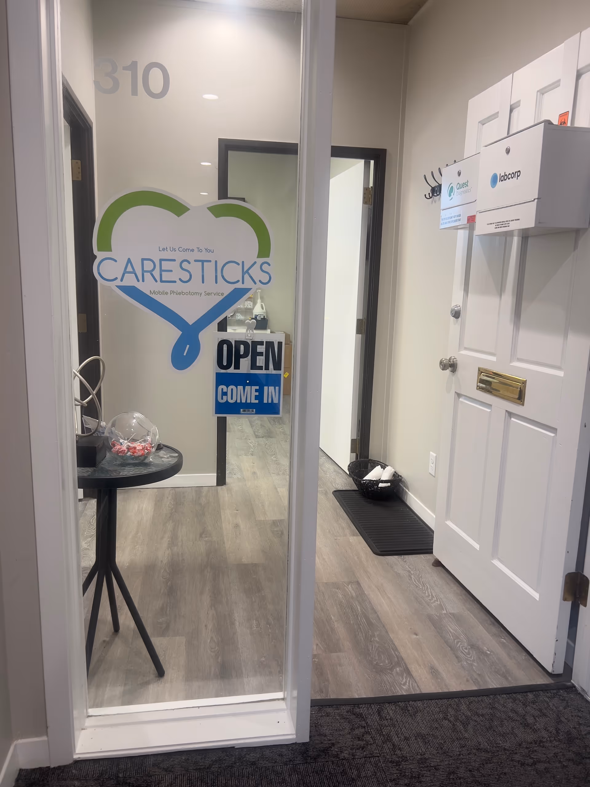Interior entry area with Caresticks logo on glass door and an open sign.