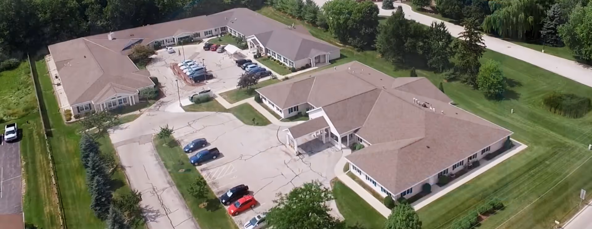 Aerial view of Springhill Adult Foster Care campus with parking lots and green lawns.