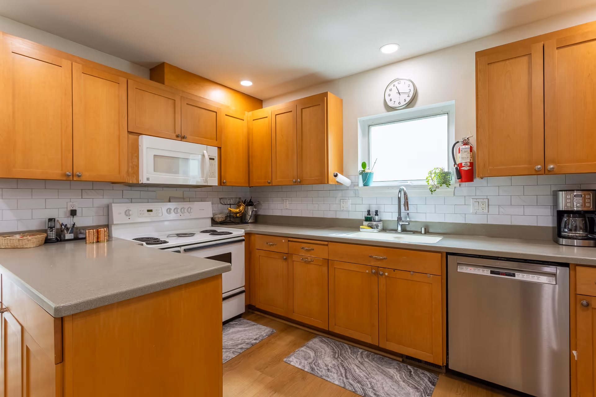 Senior living facility kitchen with wooden cabinets, appliances, and a window.