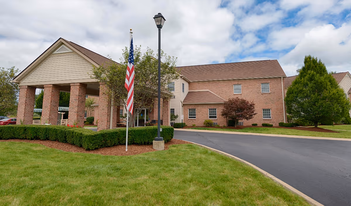 Exterior of The Suites at Continuing Healthcare of Niles, brick building with flagpole and manicured lawn.