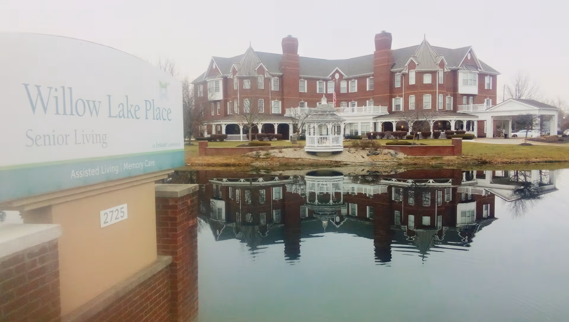 Willow Lake Place Senior Living building with pond, gazebo, and reflections.