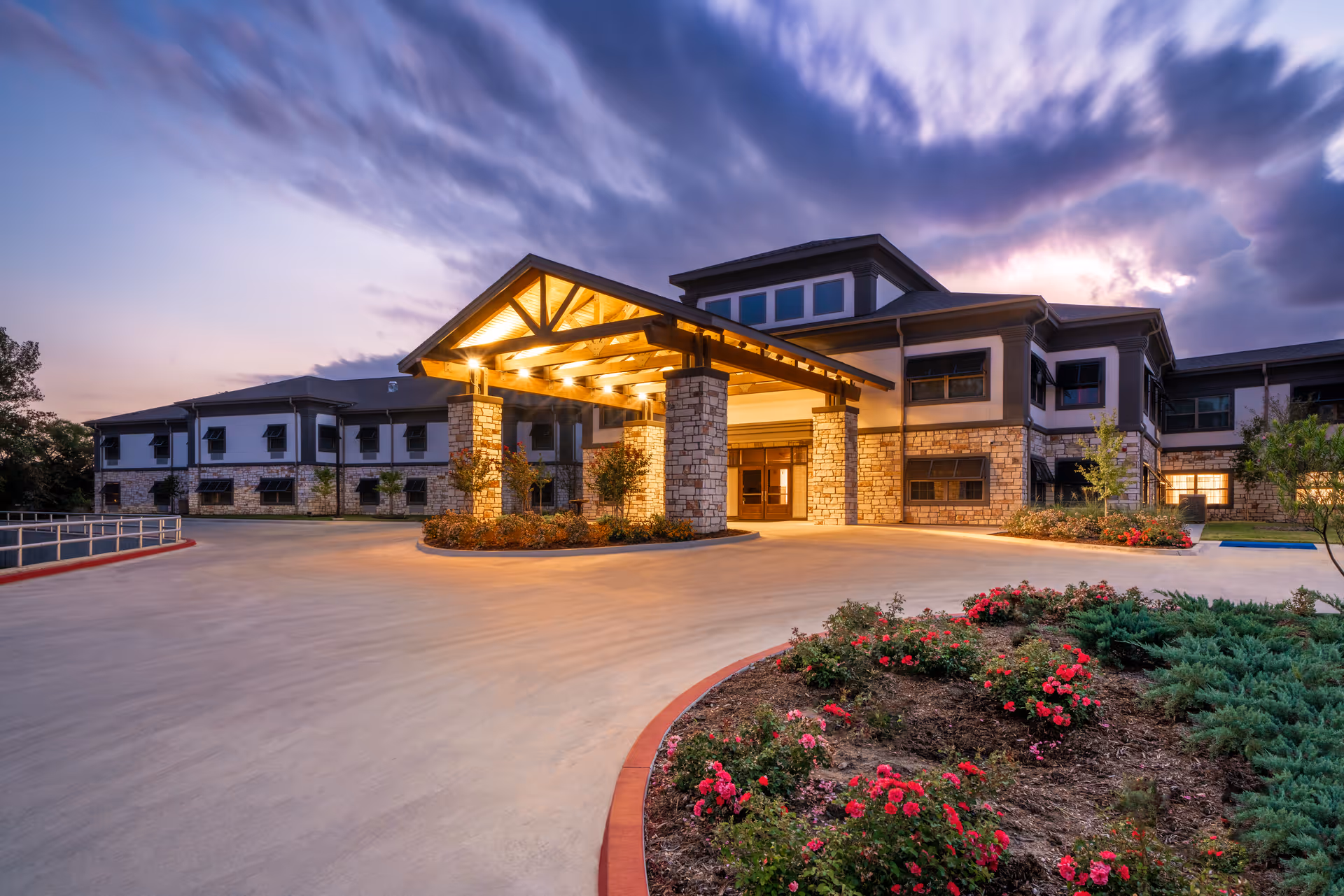 Exterior view of Aspen Health and Rehab facility with illuminated entrance and landscaped front.