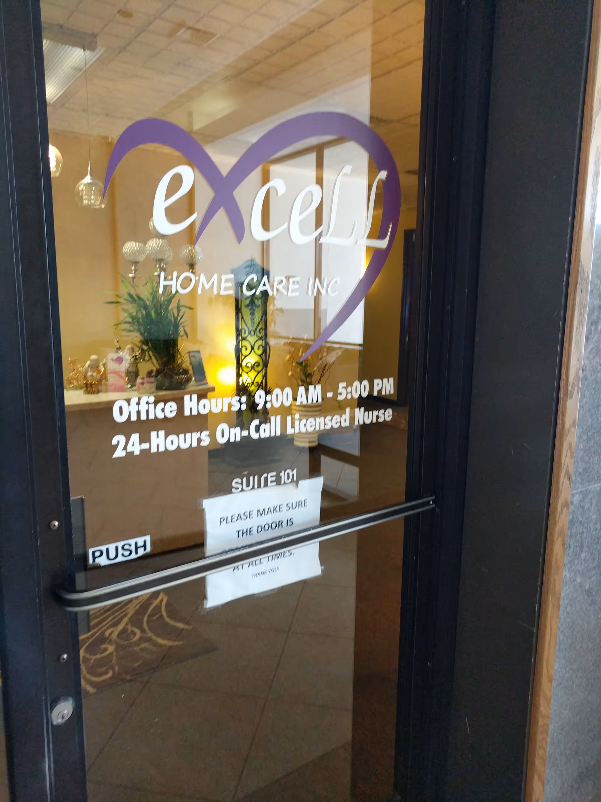 Glass door entrance with Excell Home Care Inc logo and interior decor visible.