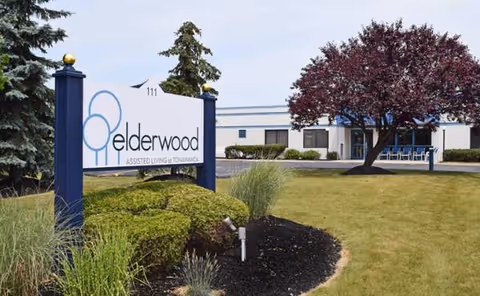 Exterior view of Elderwood Assisted Living at Tonawanda with sign, landscaping, and building.