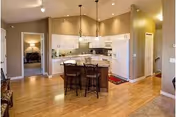 Open-concept kitchen in a Westhills Village unit with island, pendant lights, and wood floors.