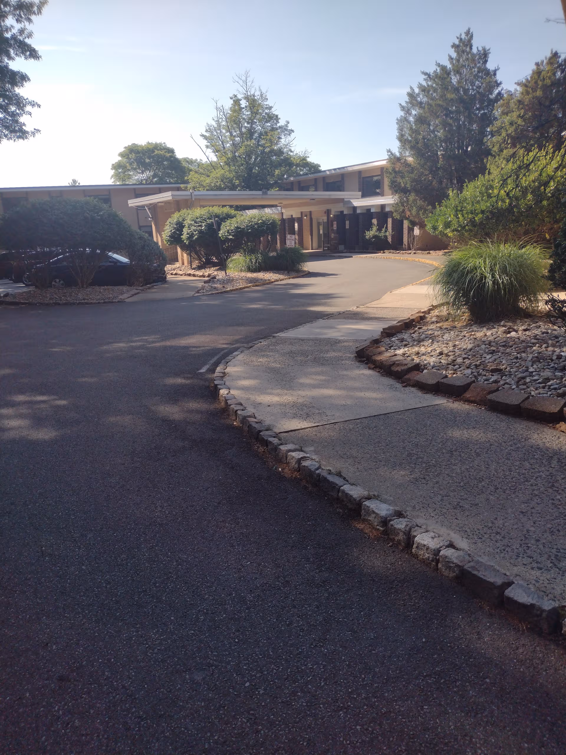 Exterior view of Complete Care at Cedar Grove entrance with curved driveway and landscaping