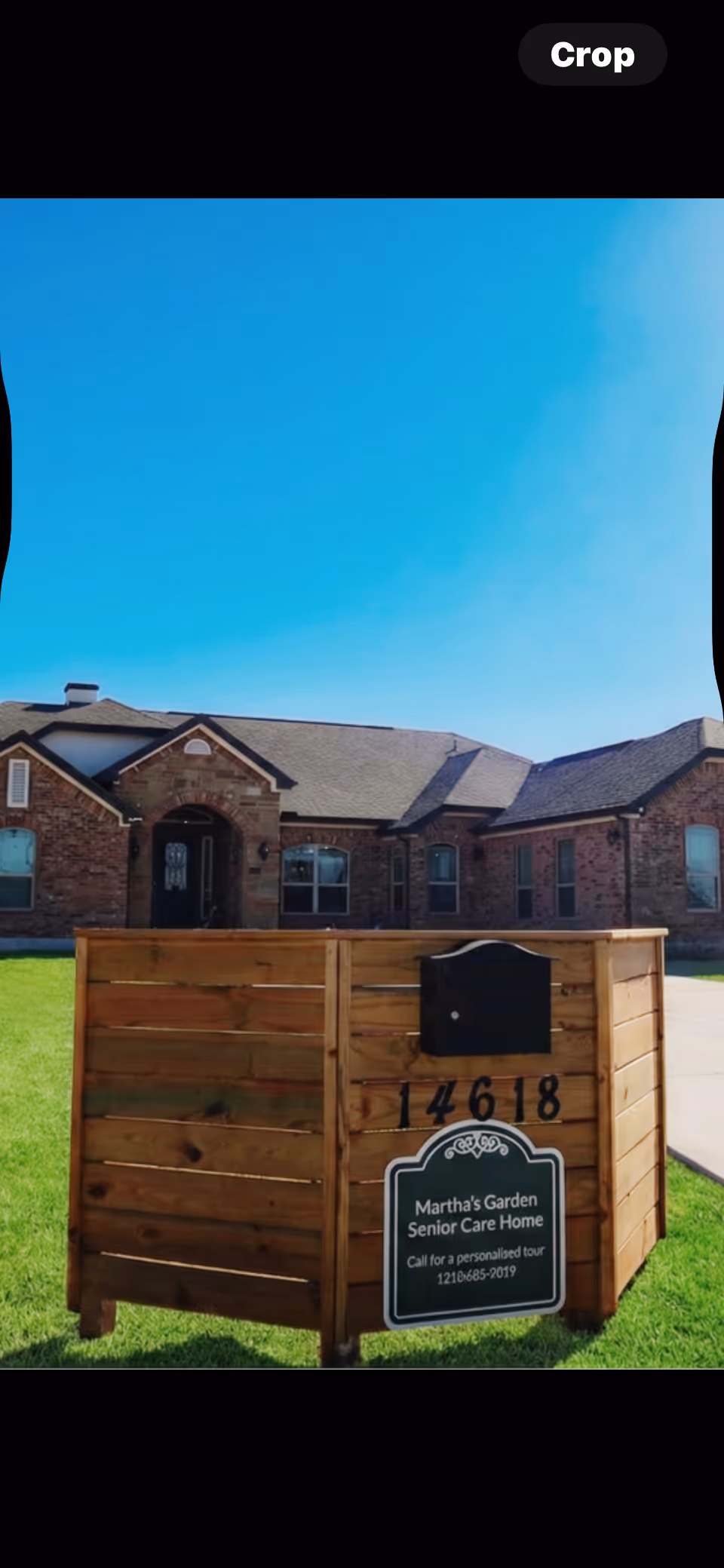 Exterior view of Martha's Garden Assisted Living with a wooden mailbox-style sign on the lawn