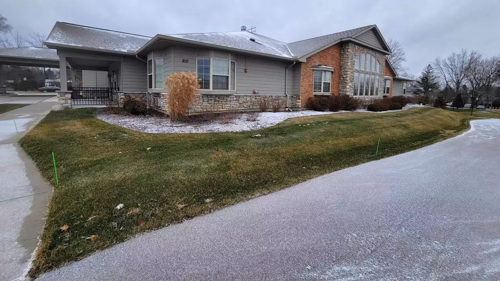 Single-story senior living facility with stone accents, large windows, and manicured lawn.
