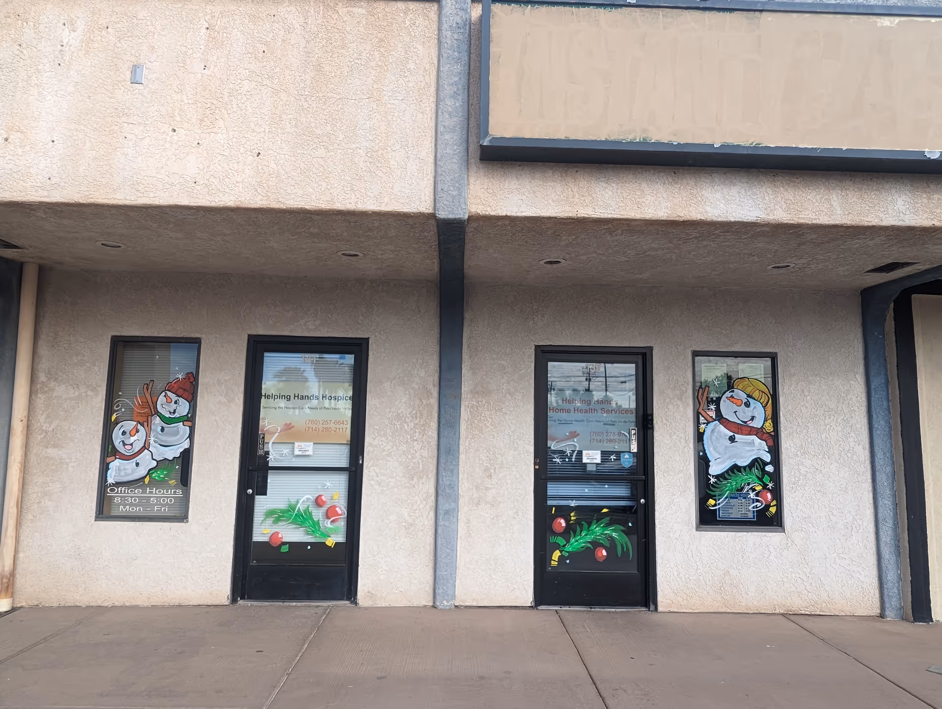 Exterior of Helping Hands Home Health Services with three doors and holiday decorations on windows.