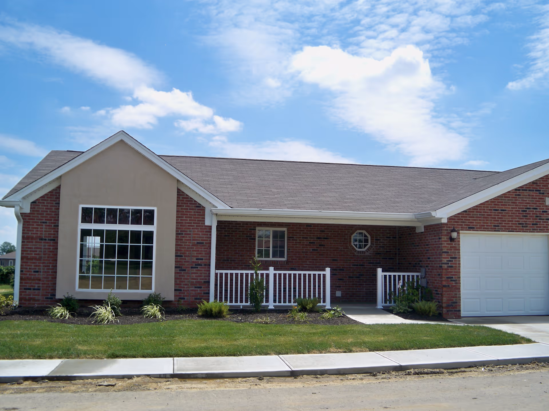 Front view of Triple Creek Retirement Community's single-story brick building with a porch.