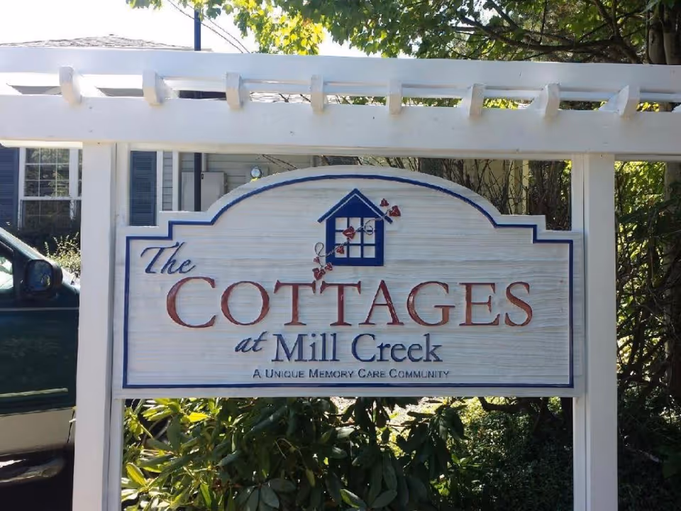 Outdoor sign reading The Cottages at Mill Creek in front of a residential building