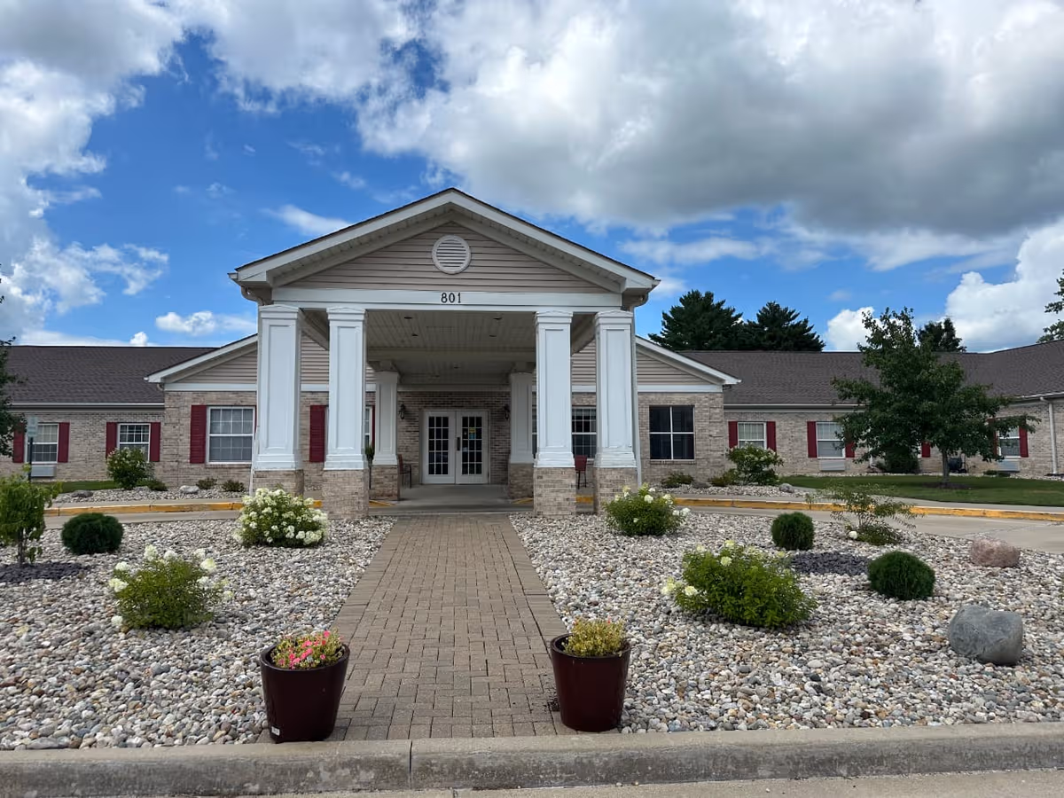 Front exterior of Tremont Ridge Assisted Living with a covered entrance and landscaped rock beds.