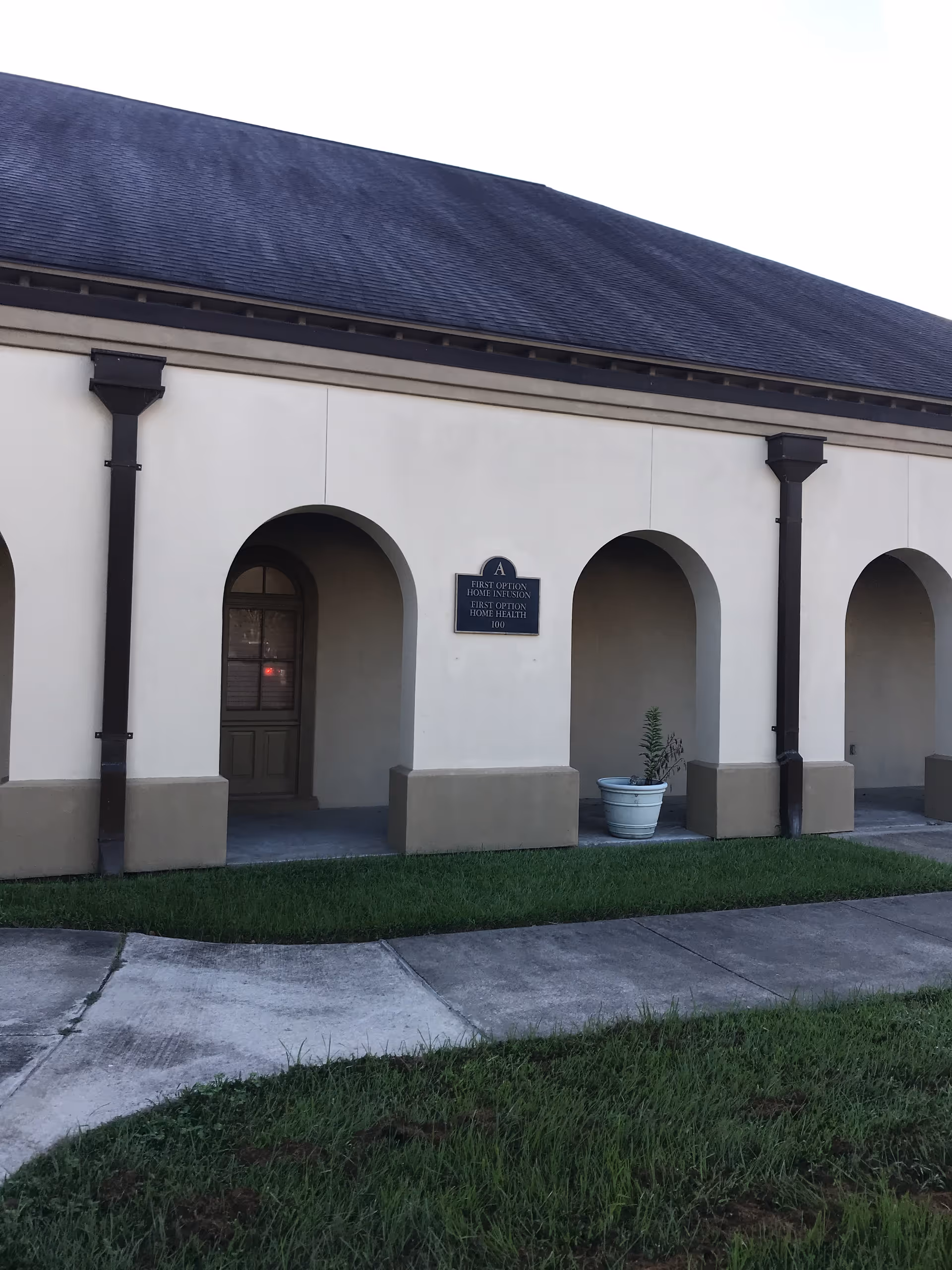 Exterior of a single-story building with arches and a sign for First Option Home Health.