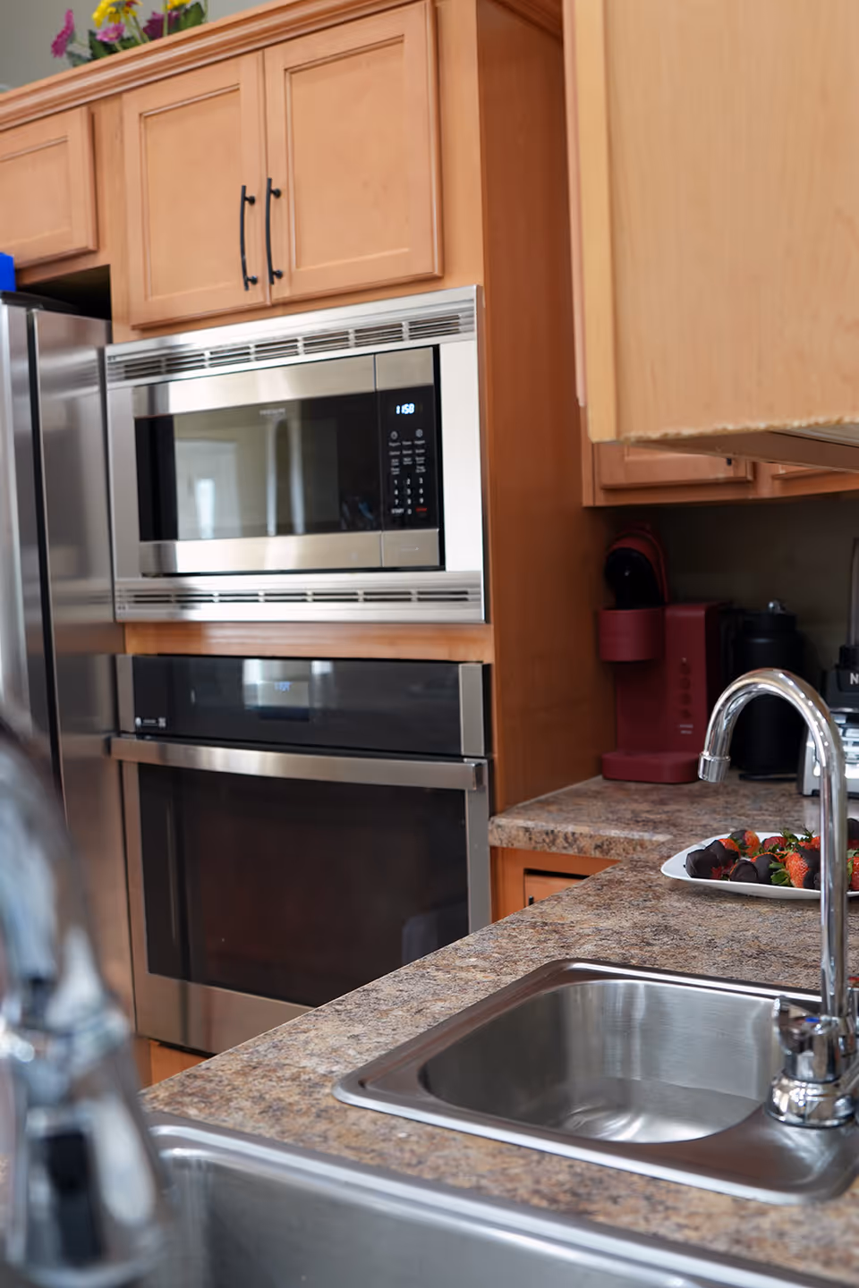 Modern kitchen in a senior living center with stainless appliances, sink, and granite counters.