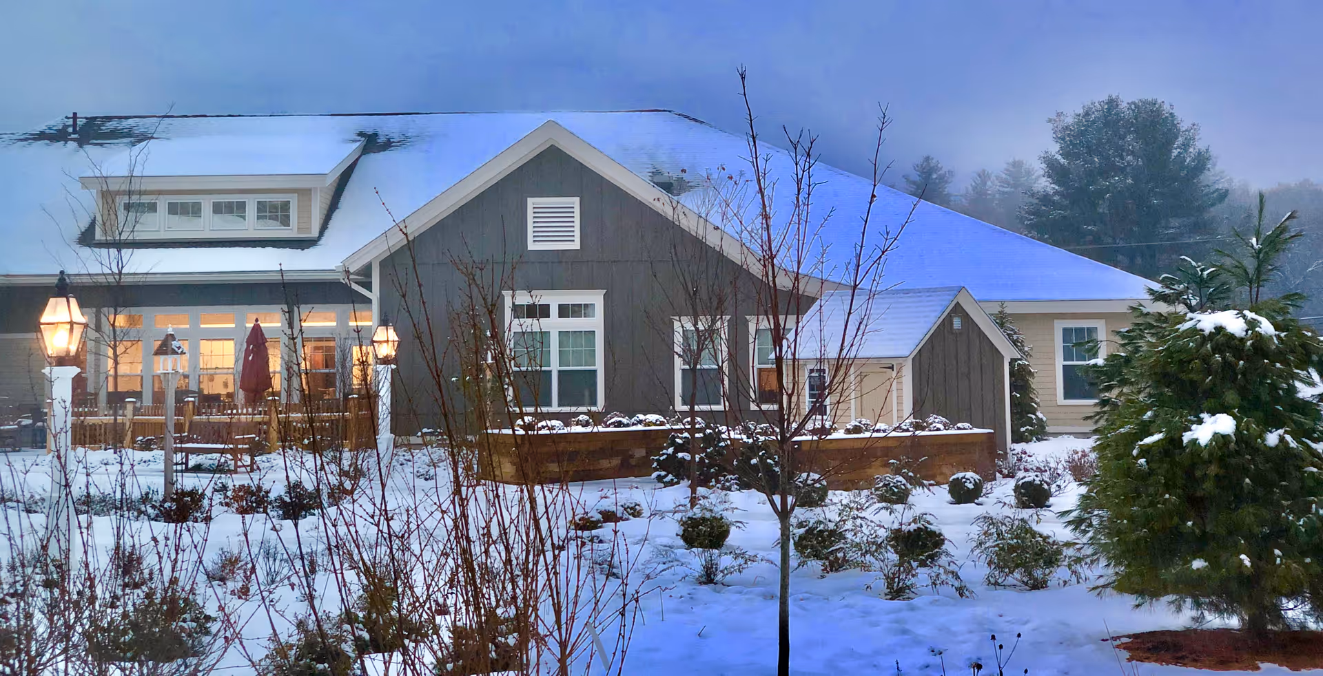 Snow-covered Bridges by EPOCH at Andover exterior with lit lamps and bare trees.