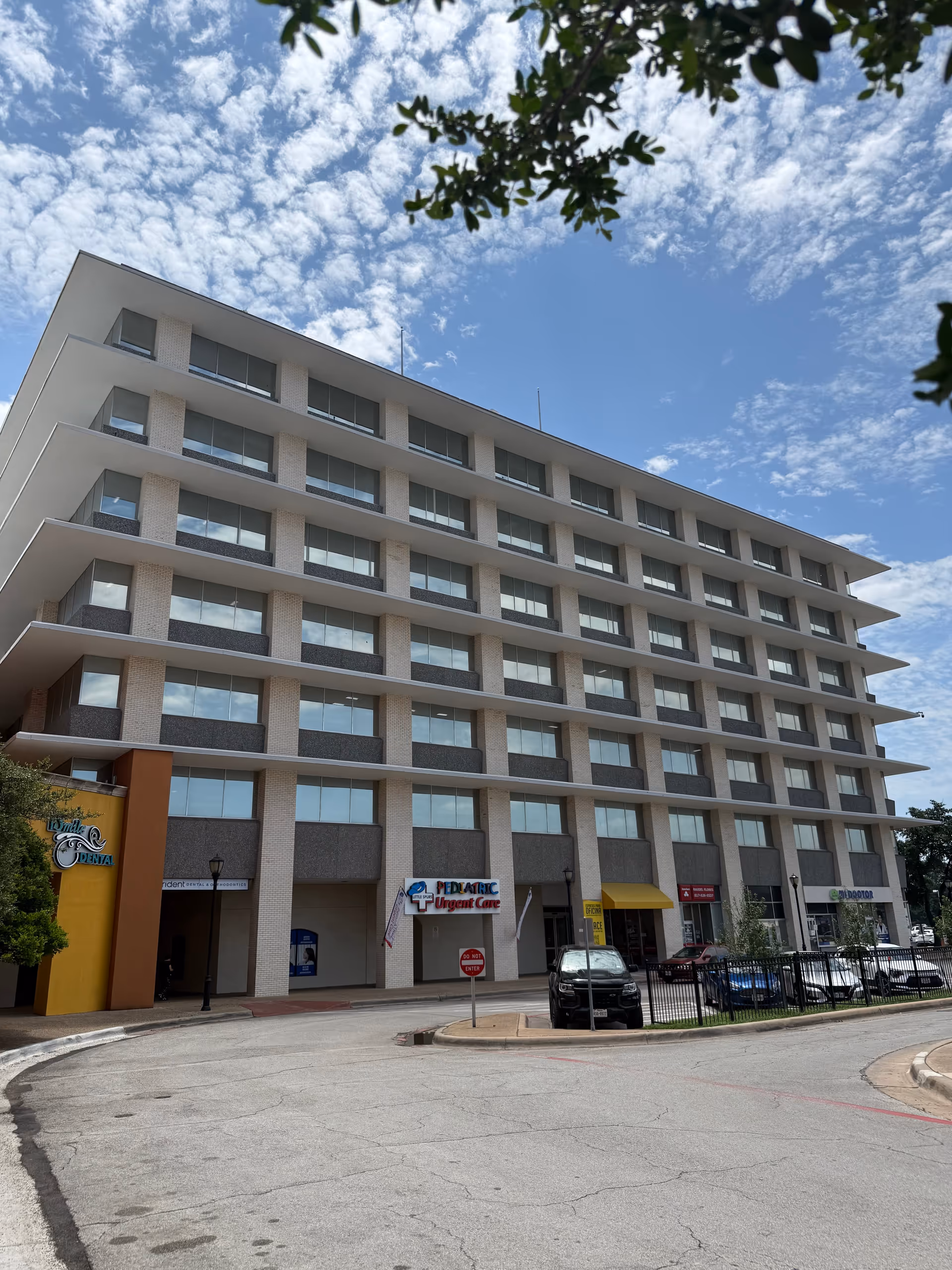 Exterior of a modern, multi-story medical building with ground-floor storefronts.