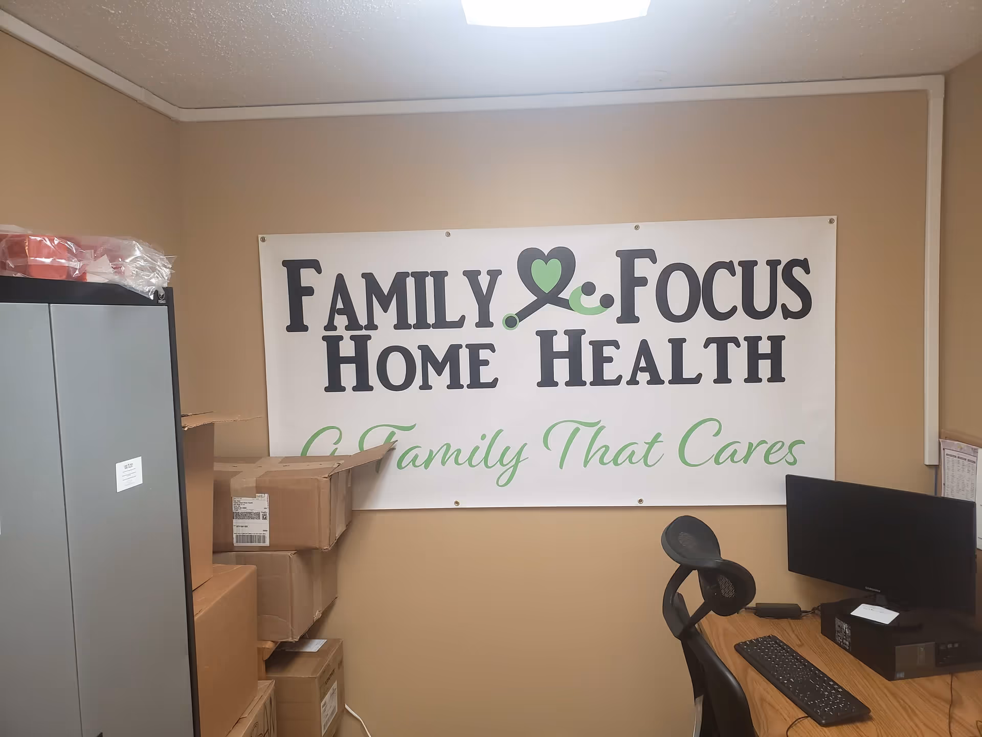Office corner inside Family Focus Home Health with banner and stacked cardboard boxes.