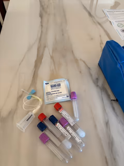 Close-up of medical supplies on a marble countertop, including Band-Aids and test tubes.