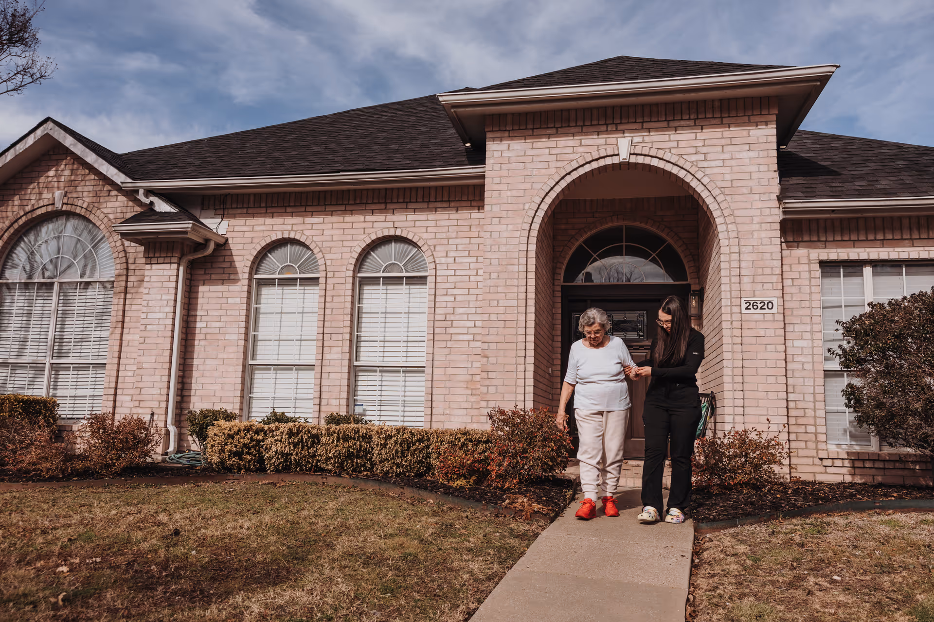 Brythaven Senior Living brick building front entrance with two people walking on sidewalk.